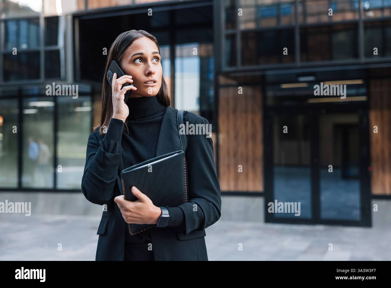 Imprenditrice sicura di sé che parla al telefono cellulare indossando eleganti abiti formali neri imprenditrice sicura di sé che parla al cellulare weari Foto Stock