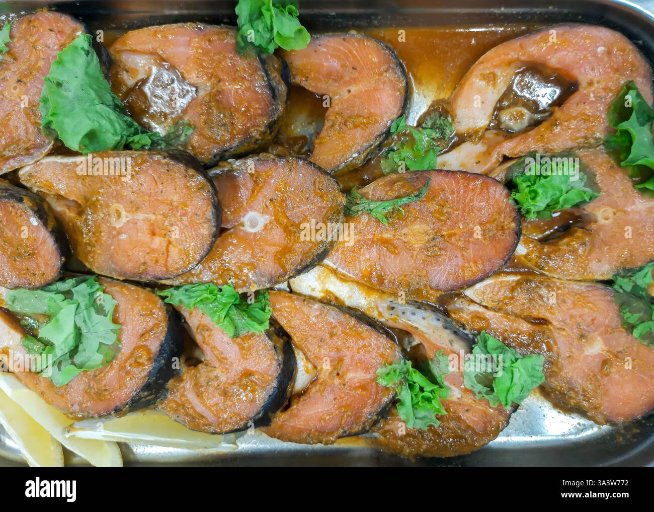 Bistecche di pesce rosso marinate con limone e spezie per grigliare Foto Stock