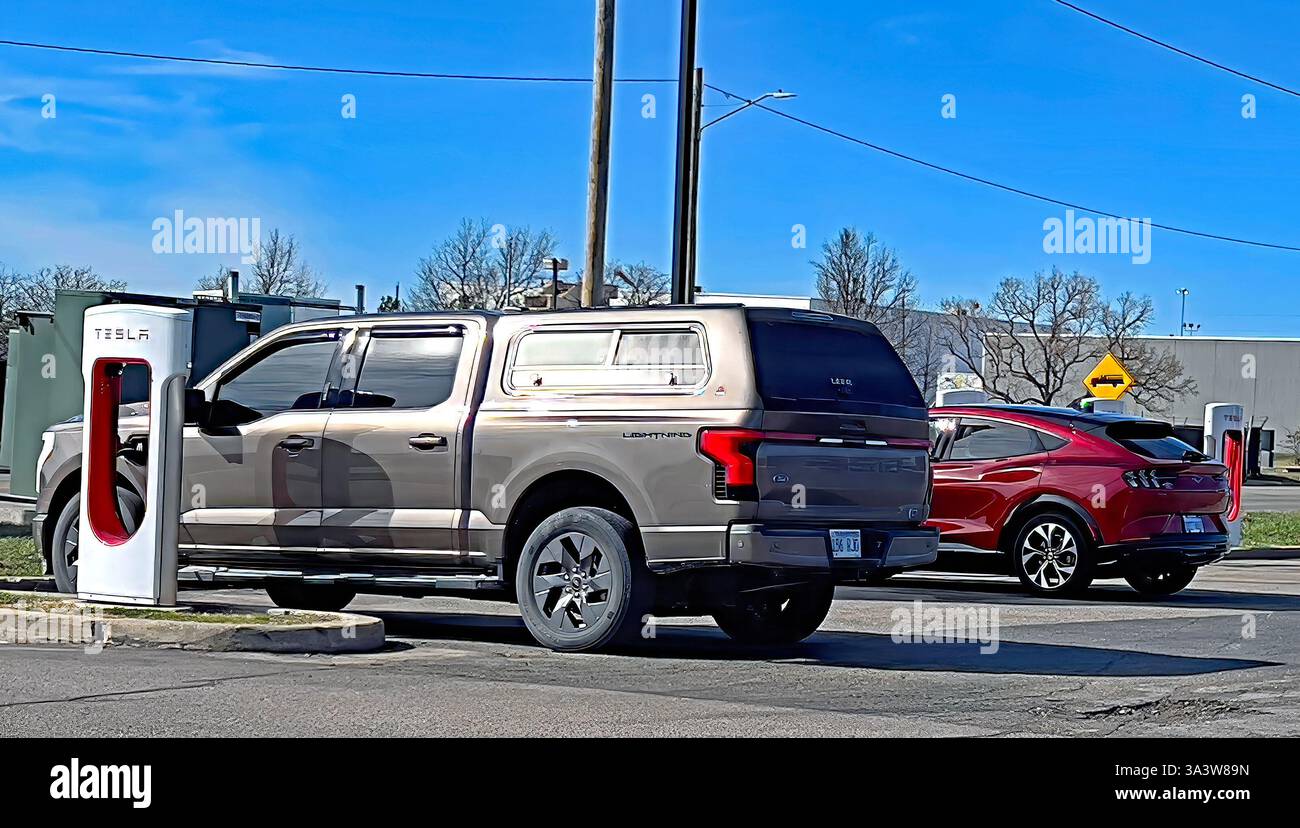 EMPORIA KANSAS, Stati Uniti - 17 MARZO 2025 giornata Ford presso la stazione di ricarica Tesla nel parcheggio dell'Emporia West Plaza. Un pick-up Ford F150 All Electric Lightning e una Ford All Electric Mustang caricano fianco a fianco Foto Stock