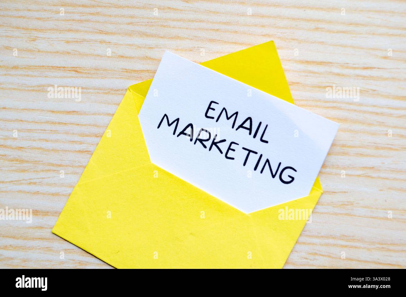 Testo di marketing tramite e-mail su blocco note bianco all'interno di una busta gialla. Fare soldi online. Foto Stock