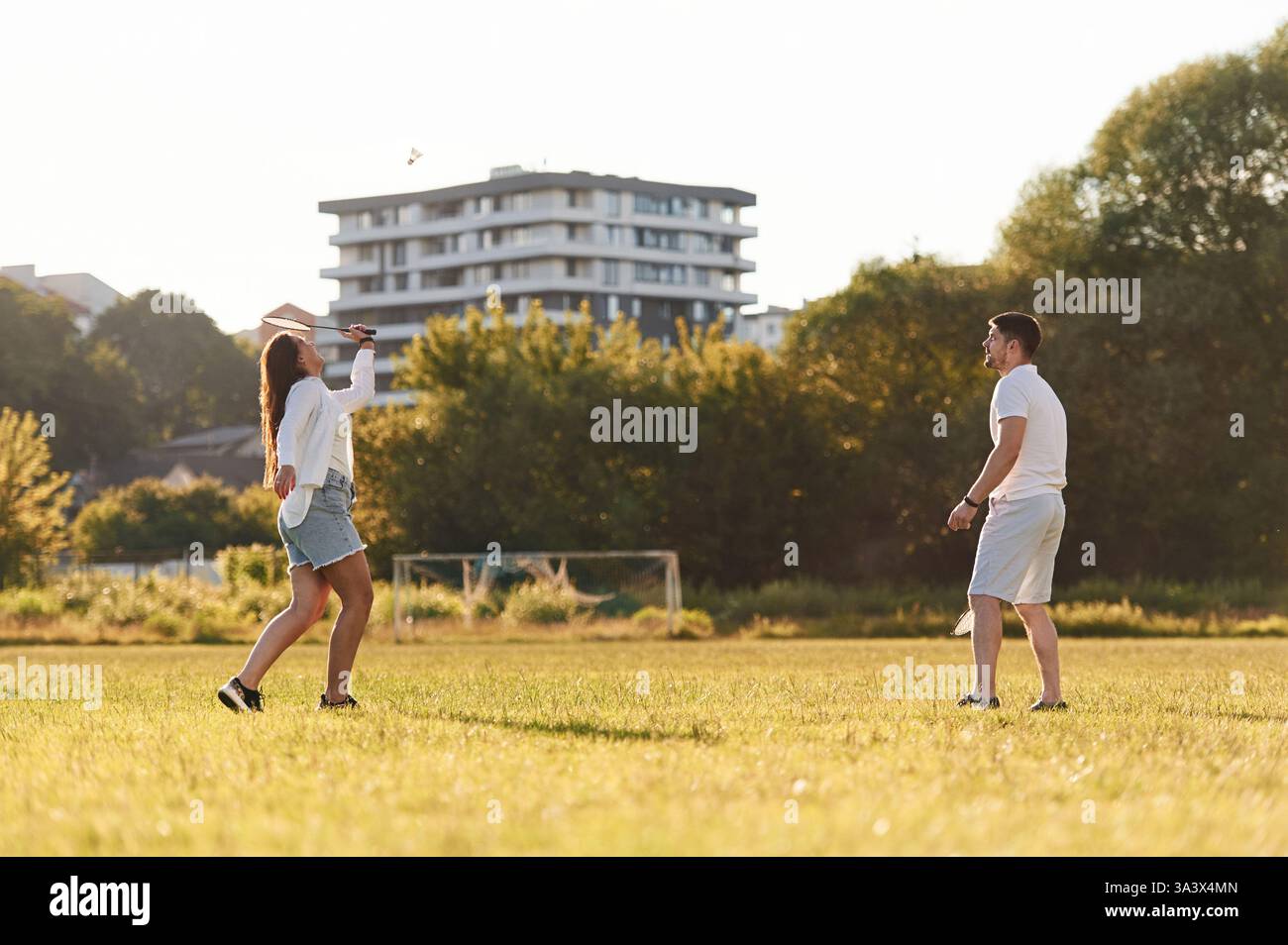 Vista laterale. L'uomo con donna gioca a badminton sul campo. Foto Stock