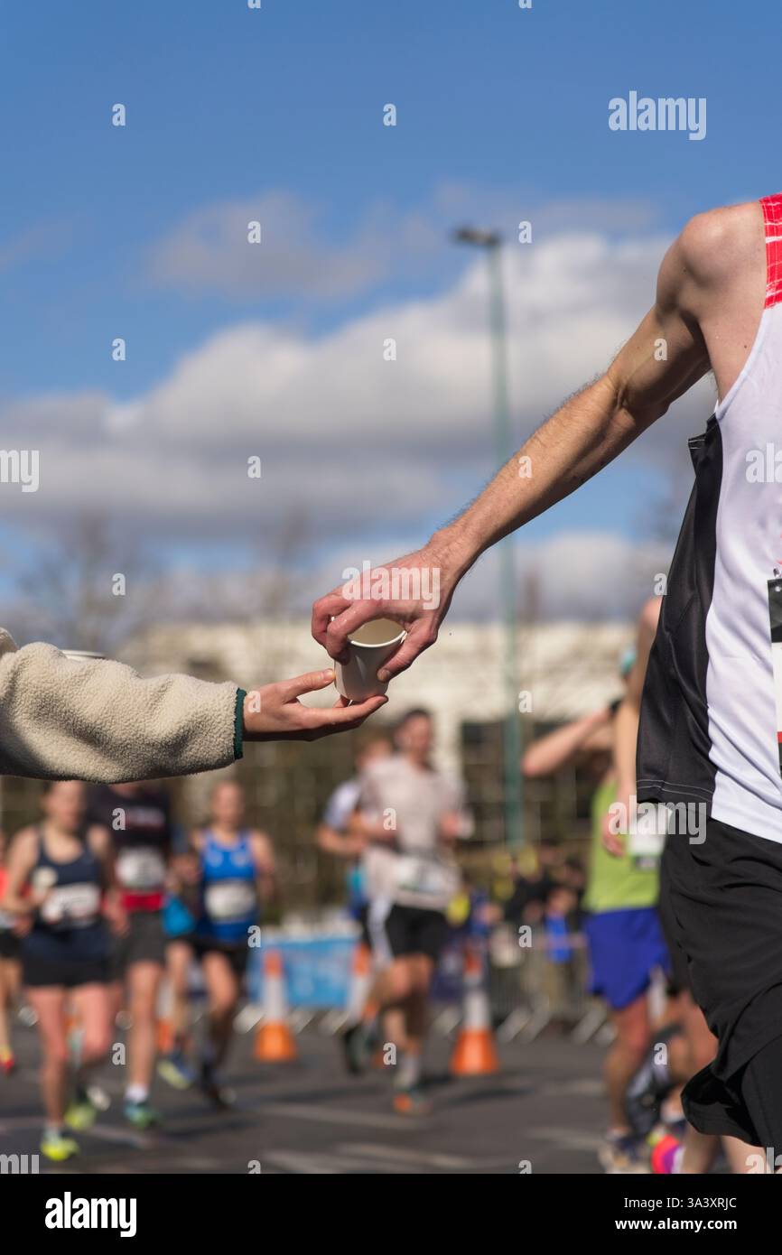 Marathon runner che ha bisogno di rinfreschi e una bevanda veloce Foto Stock