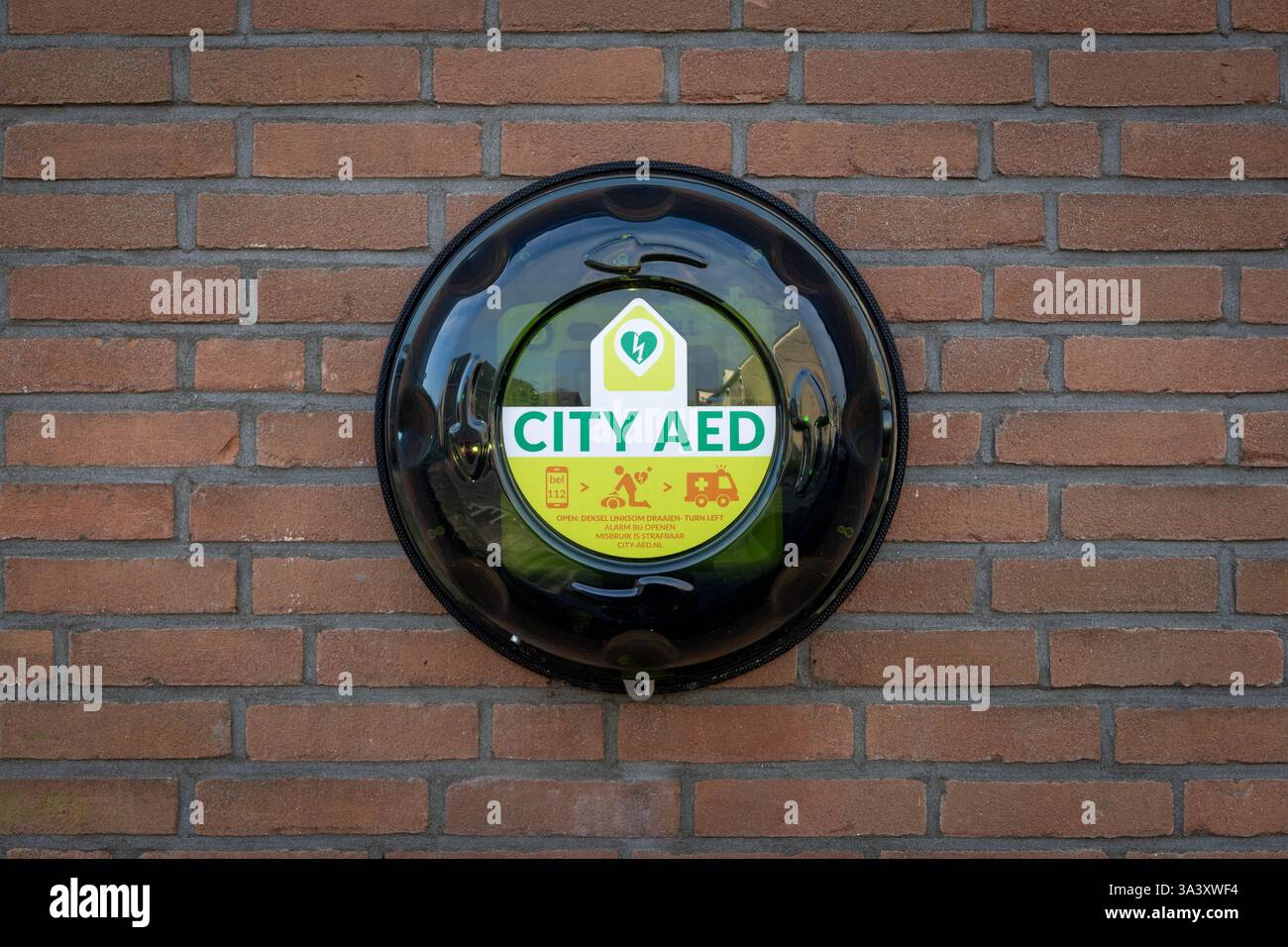 AED urbano montato su un muro in mattoni di pietra. Un defibrillatore semiautomatico esterno, o defibrillatore semiautomatico esterno, viene utilizzato per aiutare coloro che hanno subito un arresto cardiaco improvviso. Foto Stock