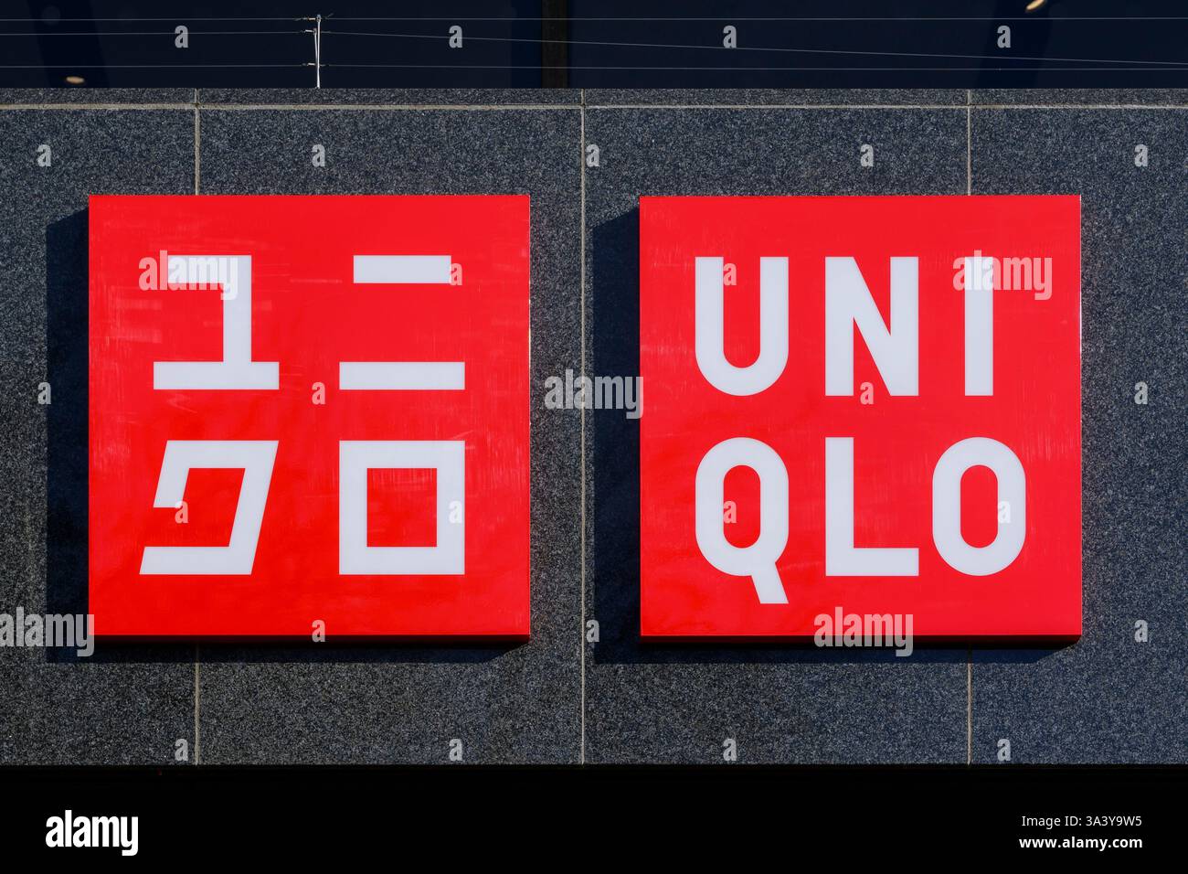 Insegna con logo Uniqlo in inglese e katakana giapponese sul negozio di Princes Street, Edimburgo, Scozia, Regno Unito Foto Stock
