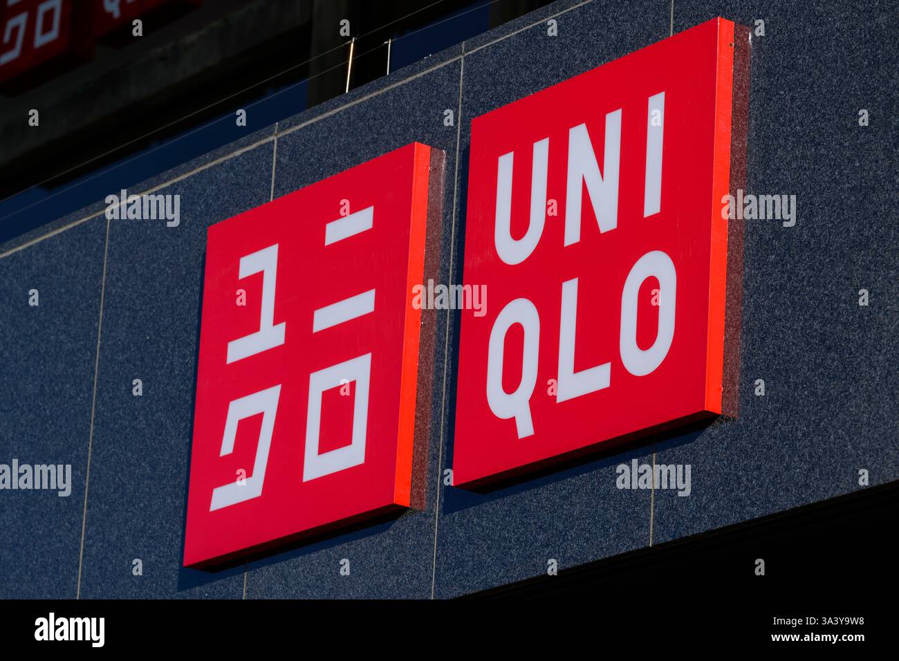 Insegna con logo Uniqlo in inglese e katakana giapponese sul negozio di Princes Street, Edimburgo, Scozia, Regno Unito Foto Stock