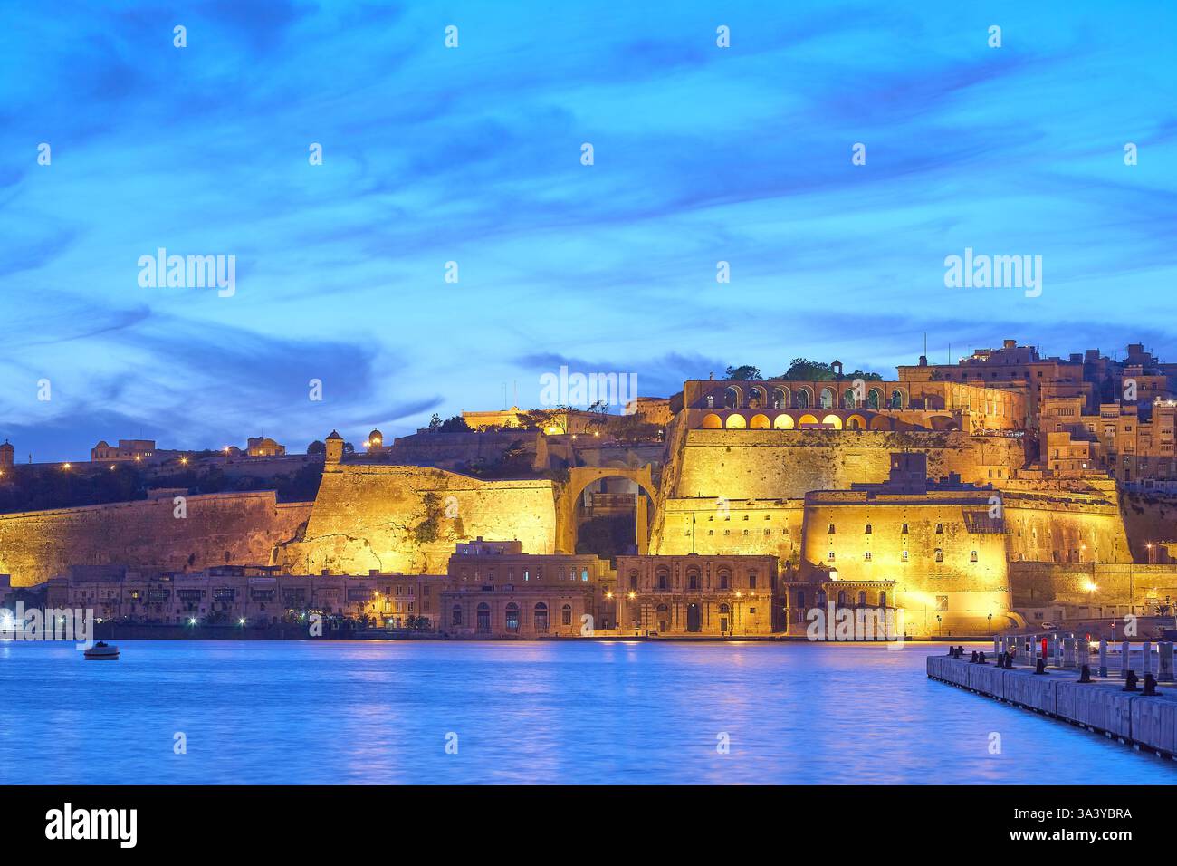 Storica città fortificata di la Valletta, Malta illuminata al tramonto dal lungomare del Grand Harbour. Foto Stock