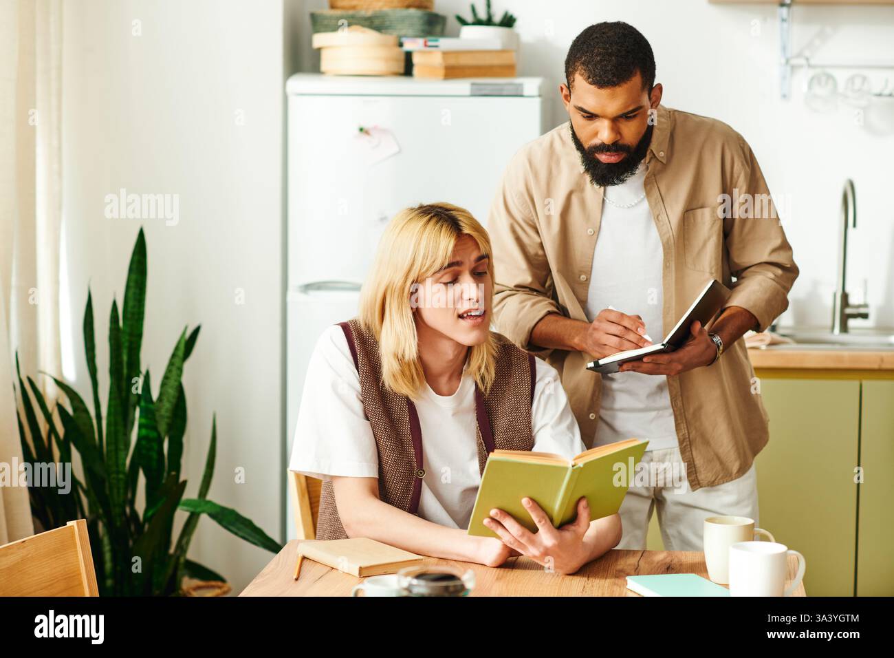 Gruppi diversi di giovani che condividono pensieri e idee durante una sessione di lettura informale a casa. Foto Stock