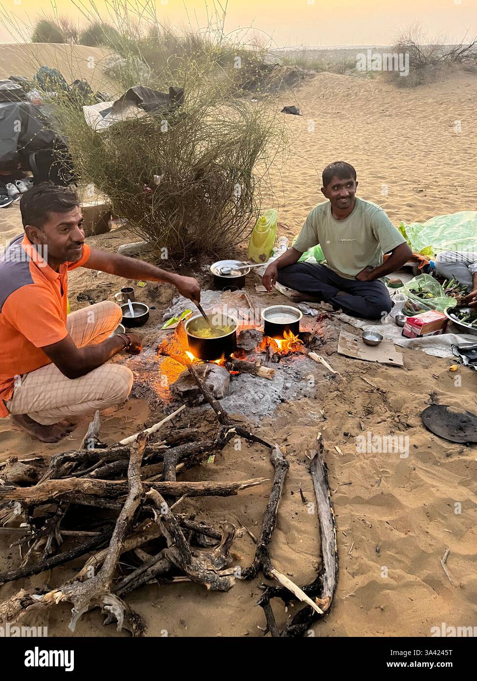 Rajasthan , India - l'uomo cucina nel deserto Foto Stock