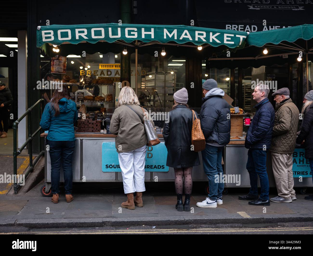 Gente in fila in una bancarella di cibo a Londons Borough Market, Inghilterra. Foto Stock