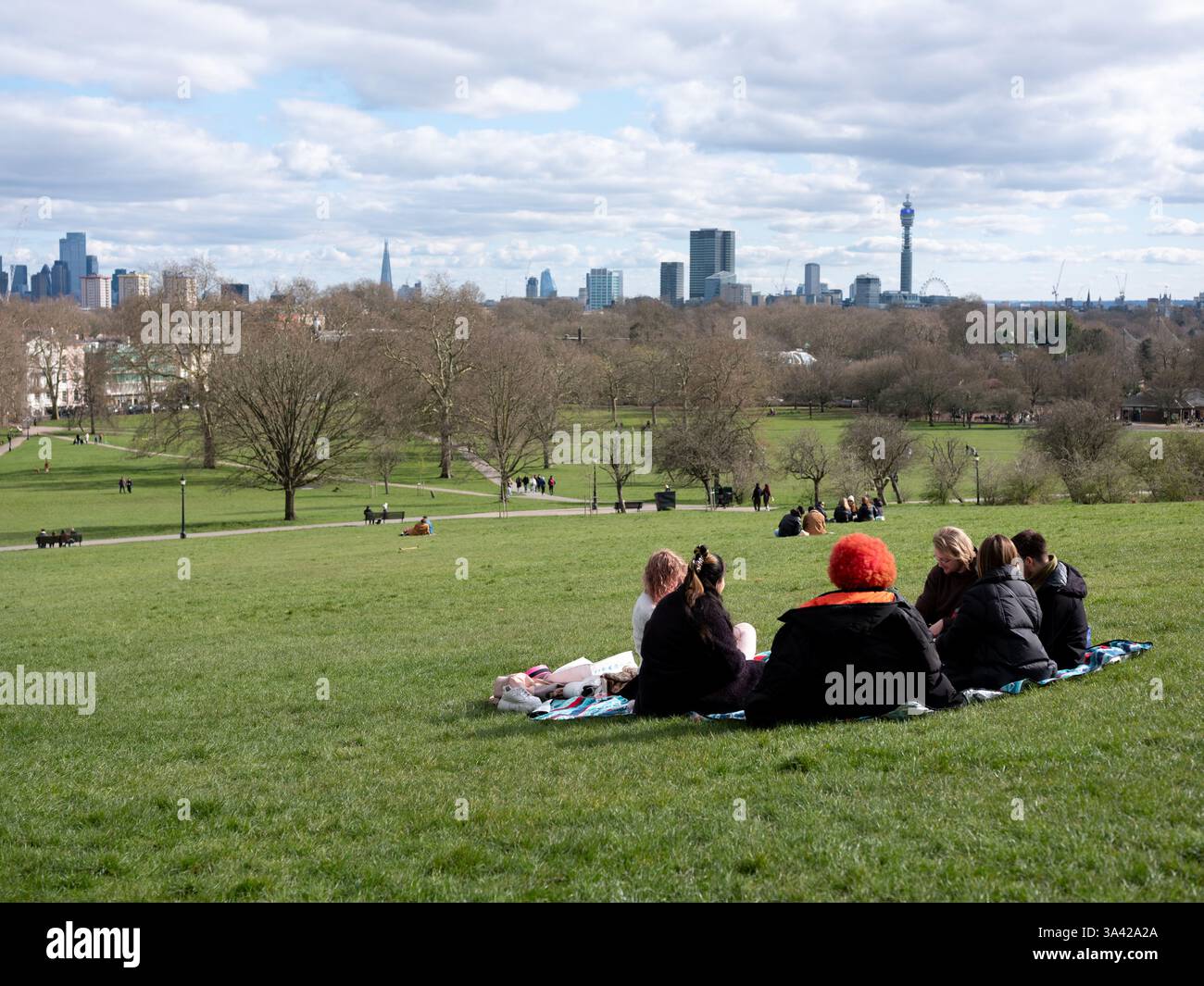 Un gruppo di amici fa un picnic a Primrose Hill, nel nord di Londra, in Inghilterra. Foto Stock