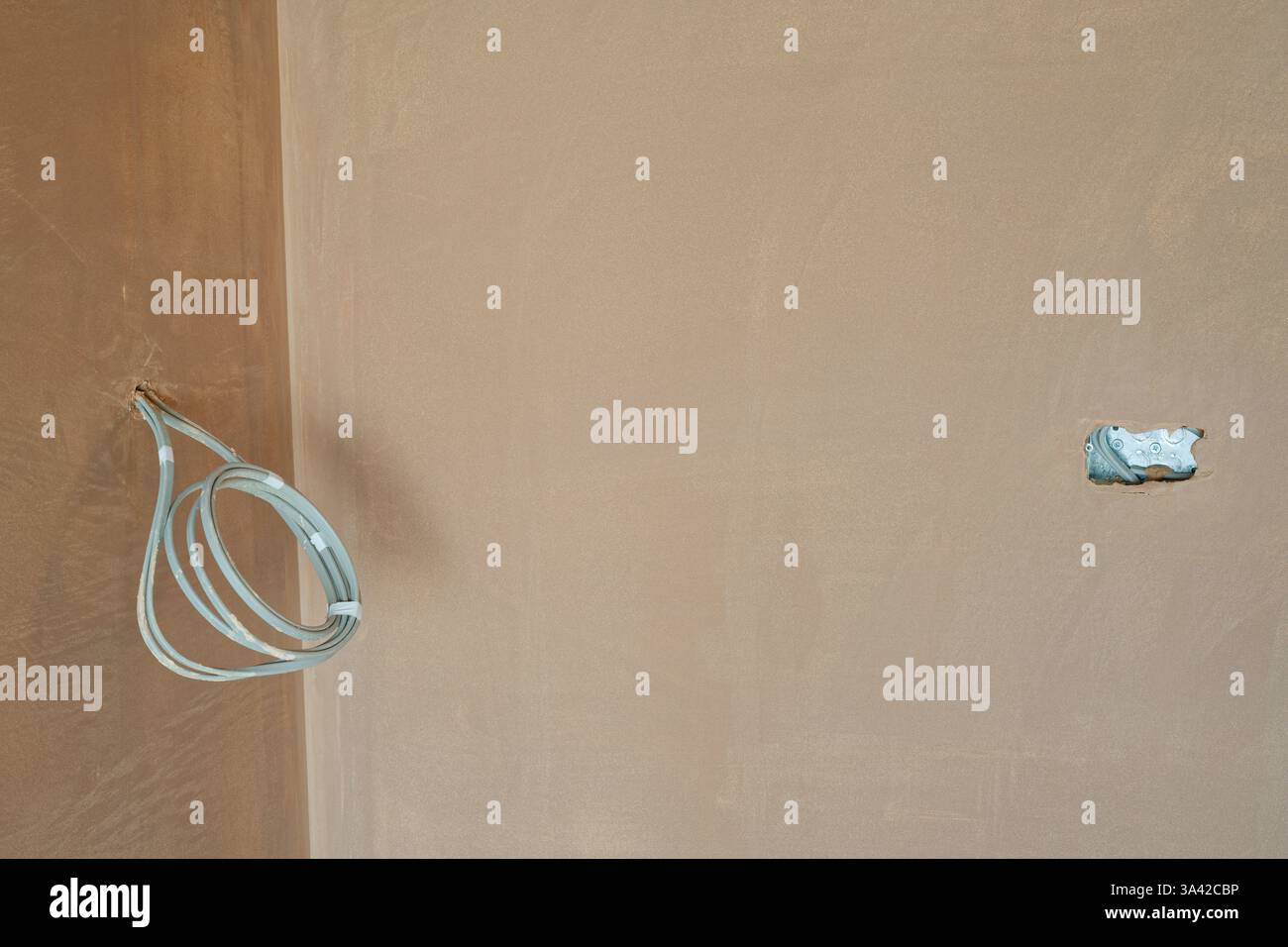 Una nuova sala intonacata con commutazione elettrica, prima installazione degli inserti per cablaggio. Lavori di costruzione rifiniti con una superficie liscia e piatta di intonaco sottile. Foto Stock