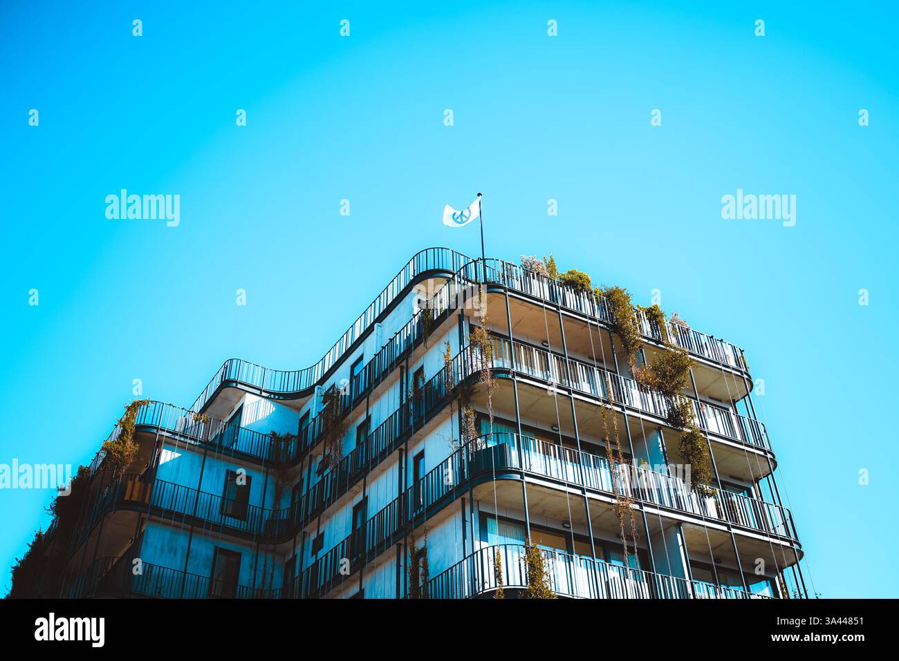 Appartamento moderno nel CBD di Hobart, Tasmania, con bandiera della pace sul tetto in tonalità blu, architettura contemporanea che simboleggia l'armonia urbana. Foto Stock