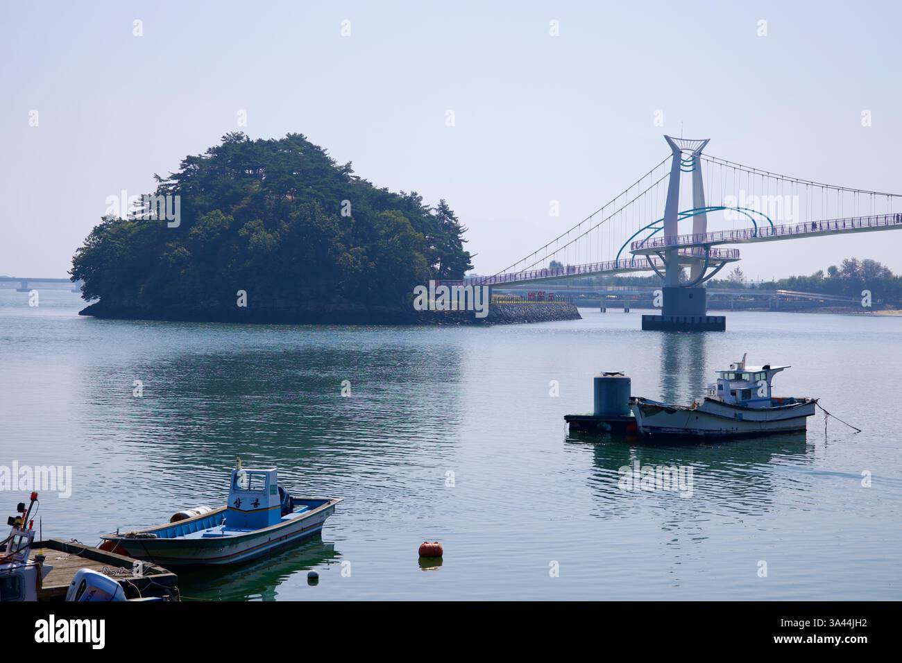 Gwangyang, Corea del Sud - 3 ottobre 2021: Una vista panoramica del ponte Byeol Heneun che collega Baealdo con la terraferma, con barche da pesca galleggianti Foto Stock