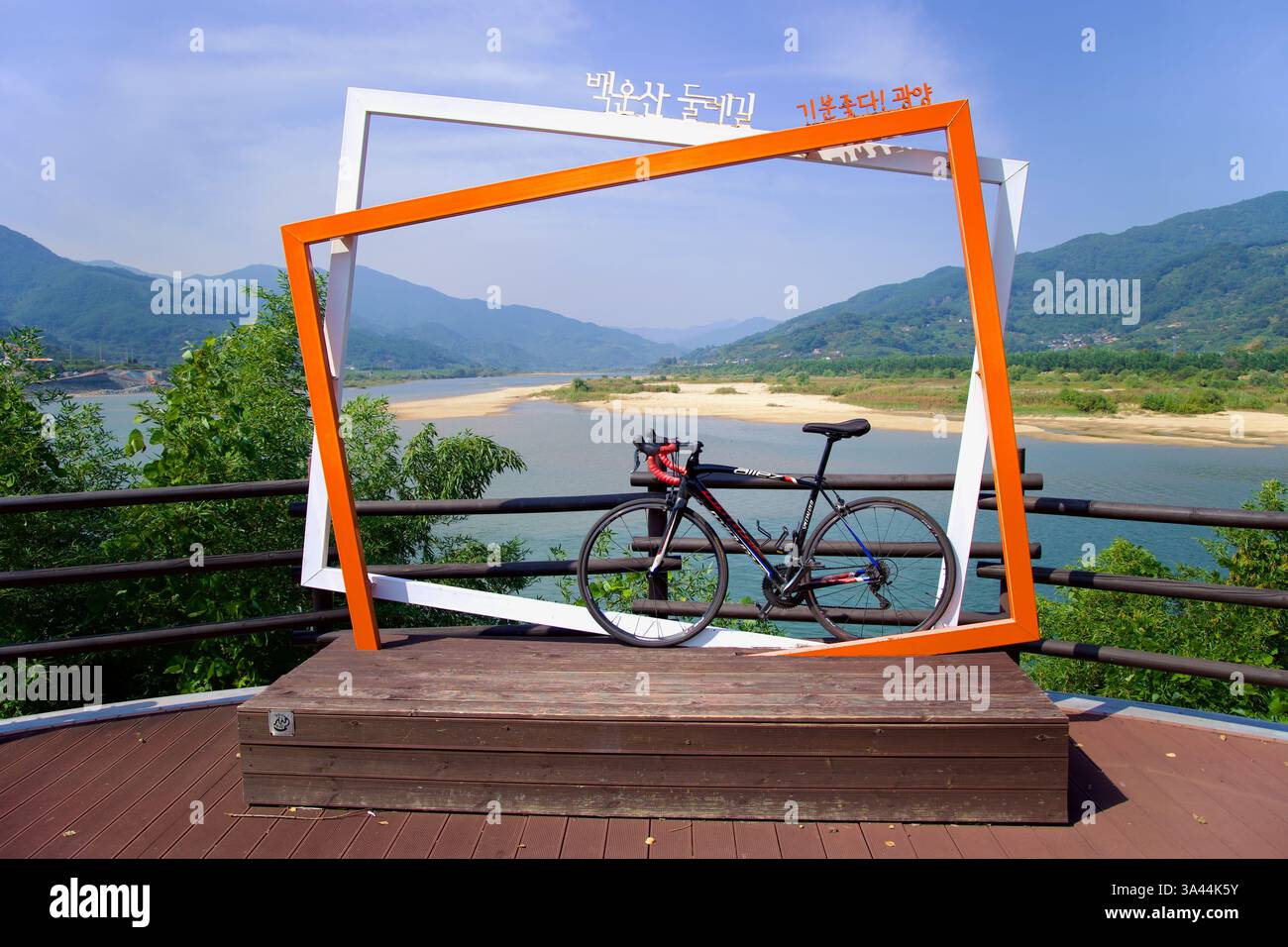 Gwangyang, Corea del Sud - 3 ottobre 2021: Una bicicletta si appoggia su una cornice fotografica panoramica in una sosta lungo il Baegunsan Dulle-gil, che offre un pano Foto Stock