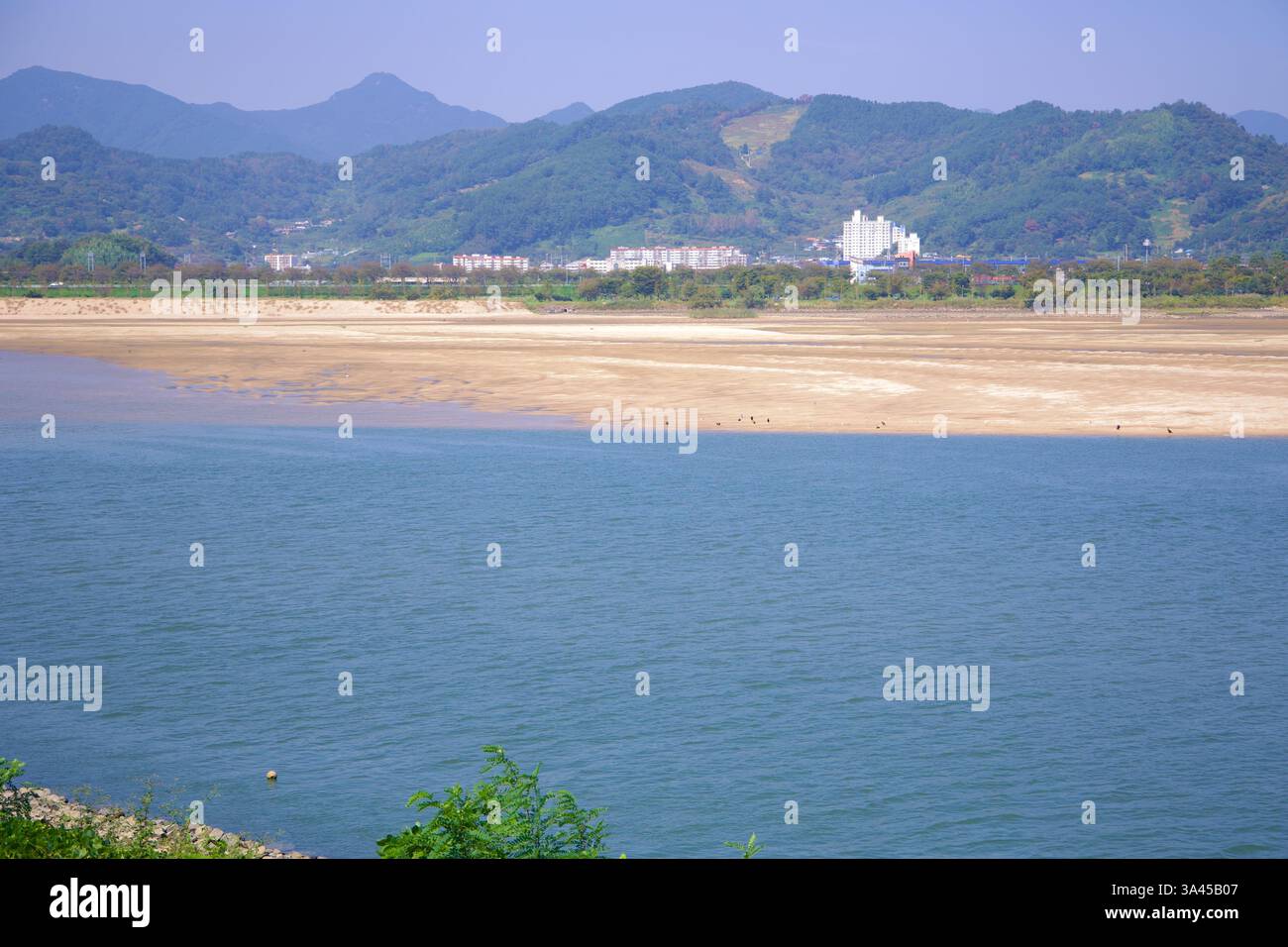 Gwangyang, Corea del Sud - 3 ottobre 2021: Una vista del fiume Seomjin con banchi di sabbia esposti, che riflettono i livelli stagionali dell'acqua. Sullo sfondo, m Foto Stock
