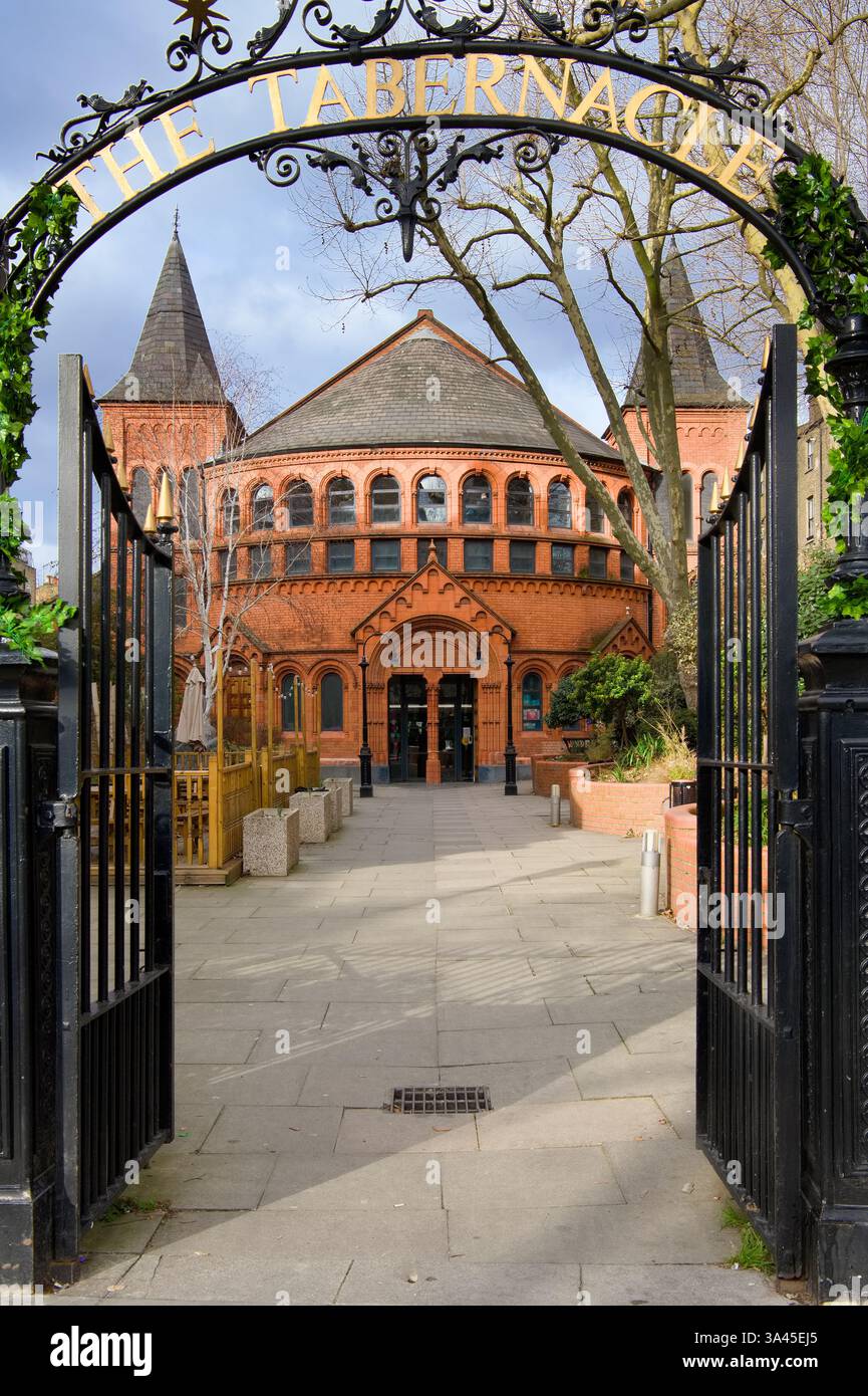 Il Tabernacle, un luogo di arte e intrattenimento a Notting Hill, Londra, visto attraverso cancelli in ferro battuto Foto Stock