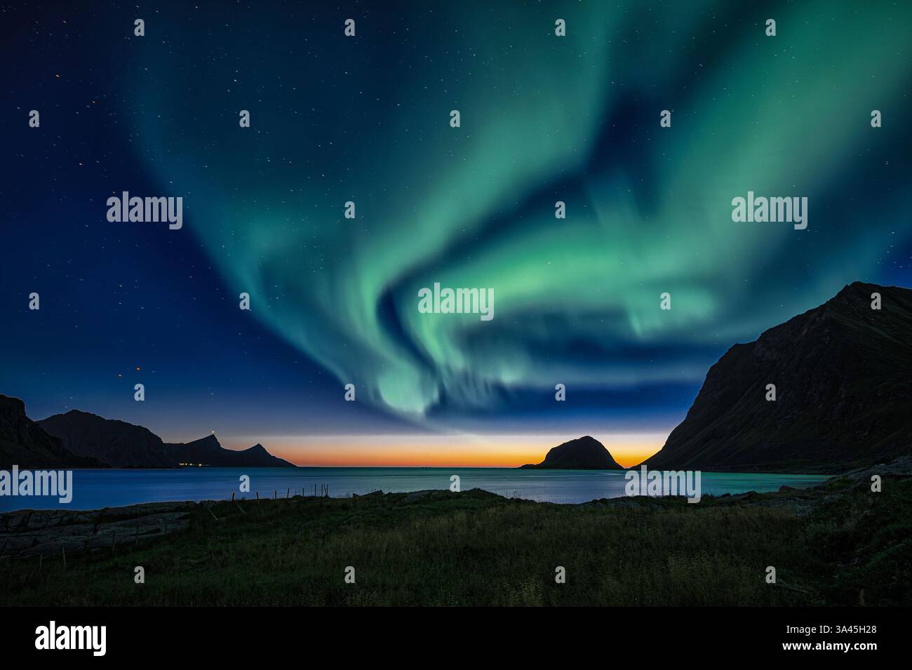 Aurora boreale verde al tramonto su un paesaggio costiero, Lofoten, Nordland, Norvegia Foto Stock