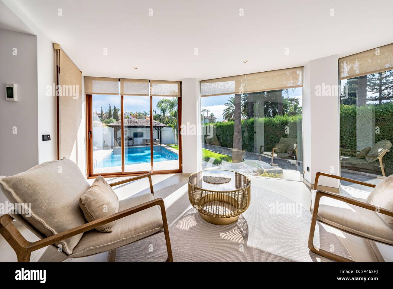 un'immagine di una lussuosa galleria panoramica in villa di lusso con vista sulla piscina privata nel giardino Foto Stock