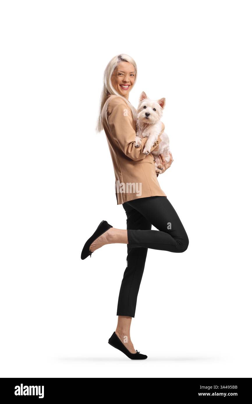 Donna felice che tiene un cane e salta isolata su sfondo bianco Foto Stock