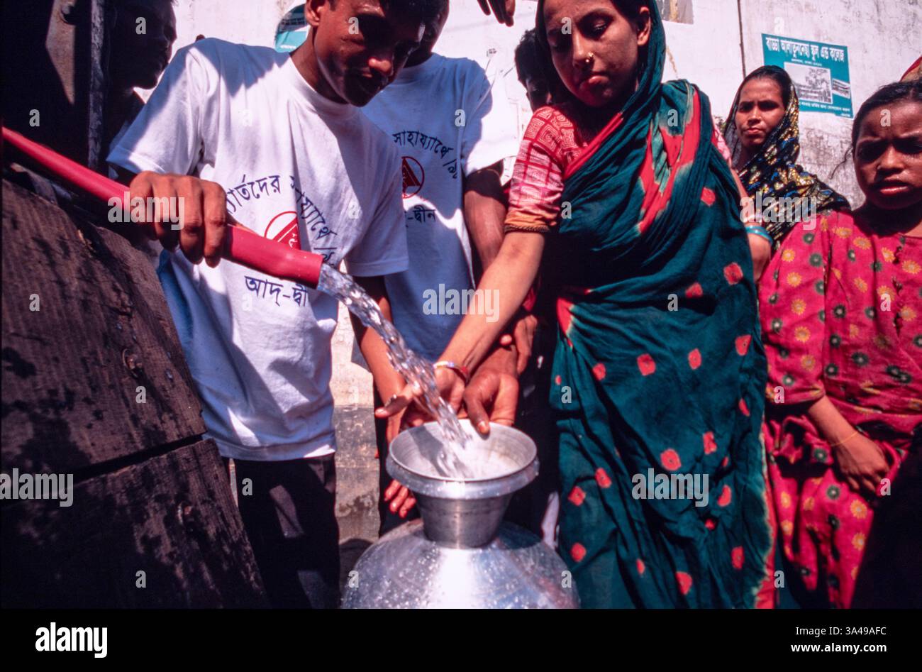 La gente fa la fila per l'acqua potabile dopo una grave inondazione a Dacca, Bangladesh, 1998 Foto Stock