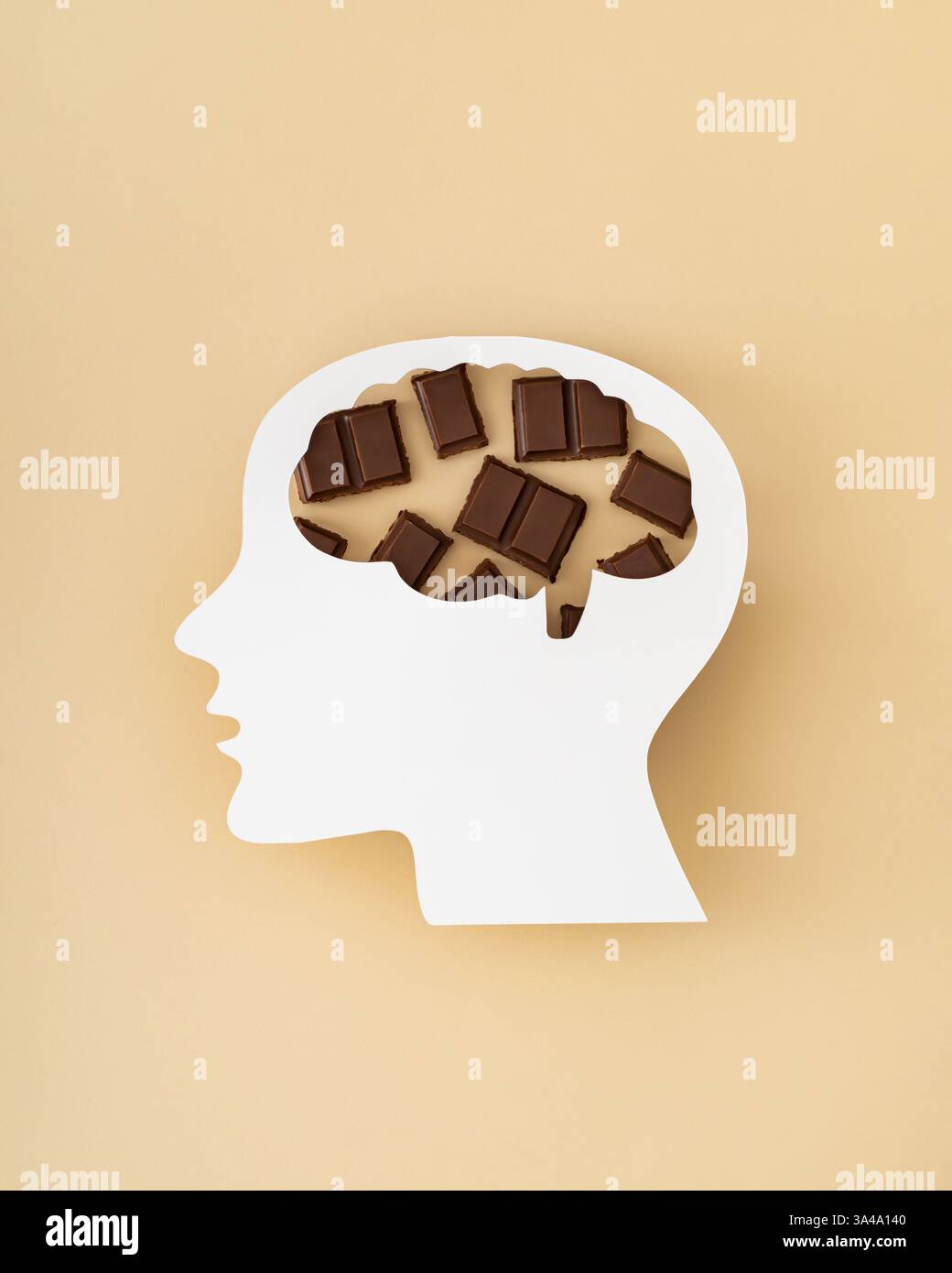 Barre di cioccolato fondente visibili attraverso un profilo della testa con intaglio di carta cerebrale su sfondo beige. Concetto di benefici per la salute del cioccolato fondente. Stile piatto Foto Stock