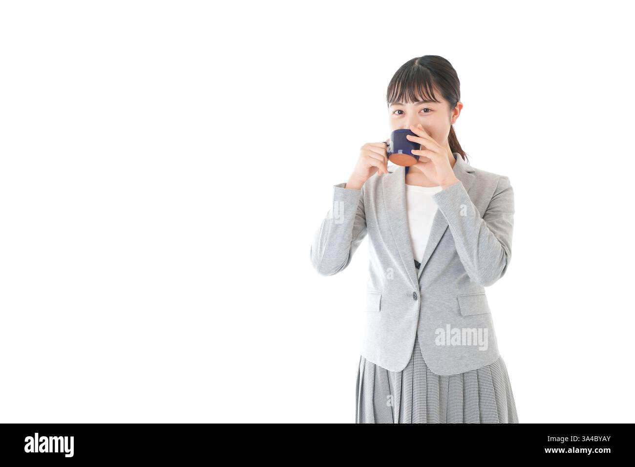Giovane donna d'affari che beve caffè con un sorriso Foto Stock