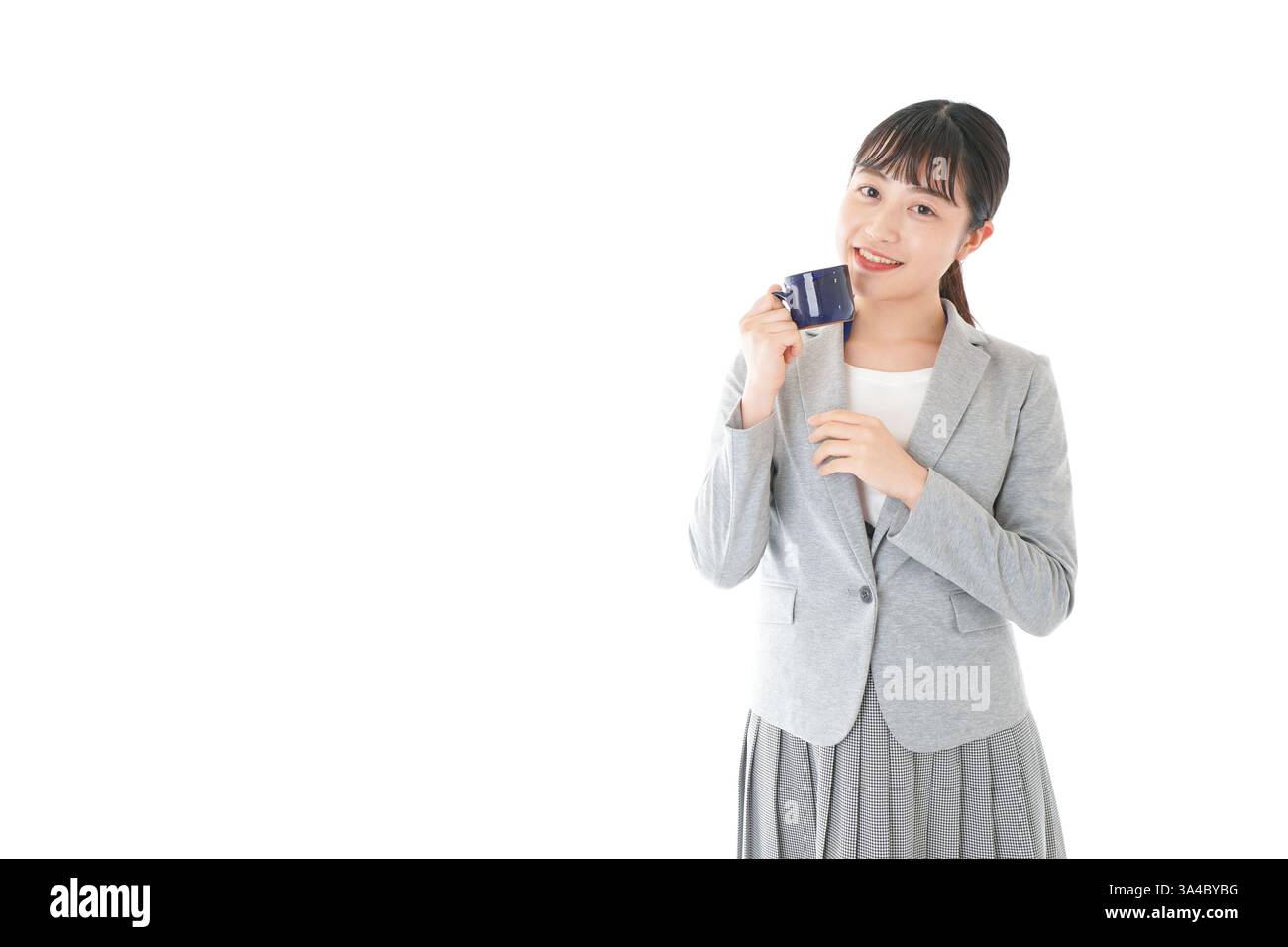 Giovane donna d'affari che beve caffè con un sorriso Foto Stock