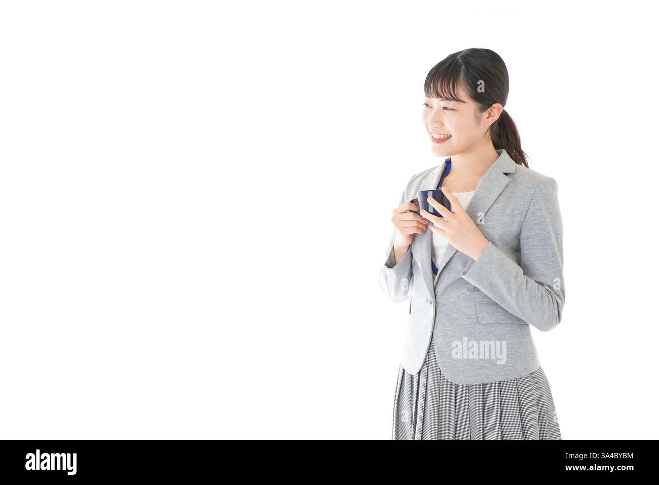 Giovane donna d'affari che beve caffè con un sorriso Foto Stock