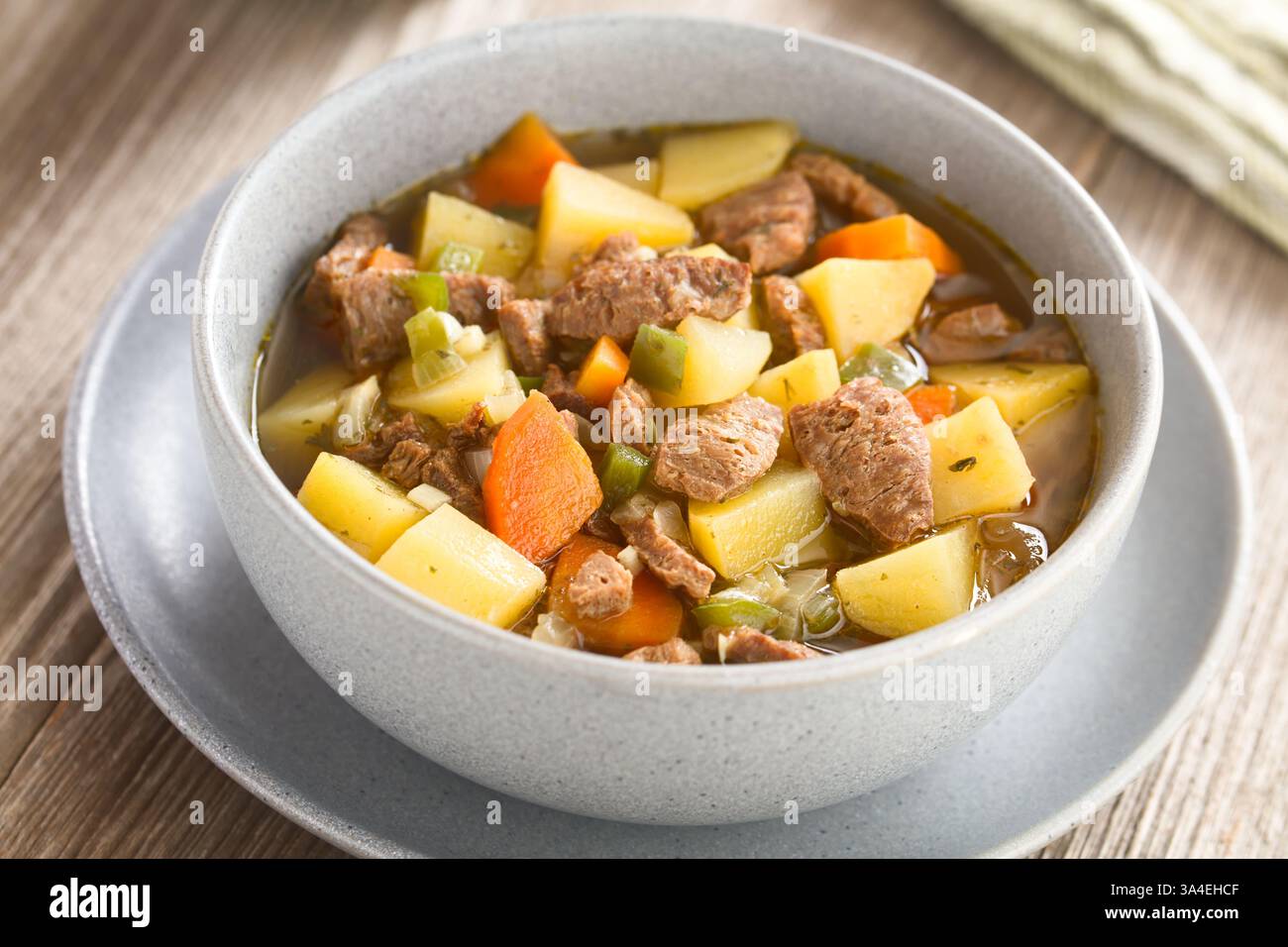 Zuppa vegana o stufato a base di patate vegetali, cipolla, aglio, carota, pepe verde e pezzi di carne di soia, serviti nel recipiente (messa a fuoco selettiva) Foto Stock