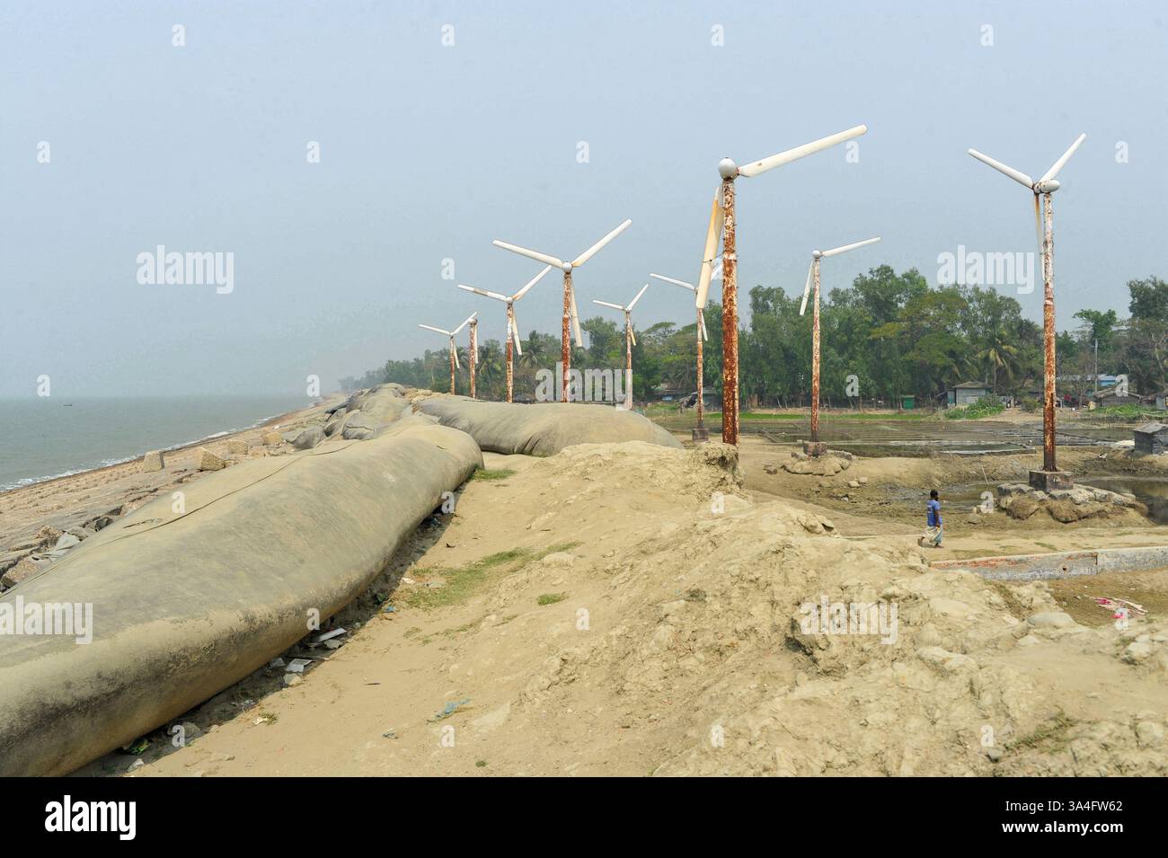 Un tempo simbolo di speranza per l'energia verde, le turbine eoliche arrugginite sull'isola di Kutubdia sono ora abbandonate. Una volta operativa e generatrice di elettricità, sono cadute in rovina, sollevando preoccupazioni per la cattiva gestione e il futuro delle iniziative del Bangladesh in materia di energie rinnovabili. Isola di Kutubdia, Bangladesh. Foto Stock
