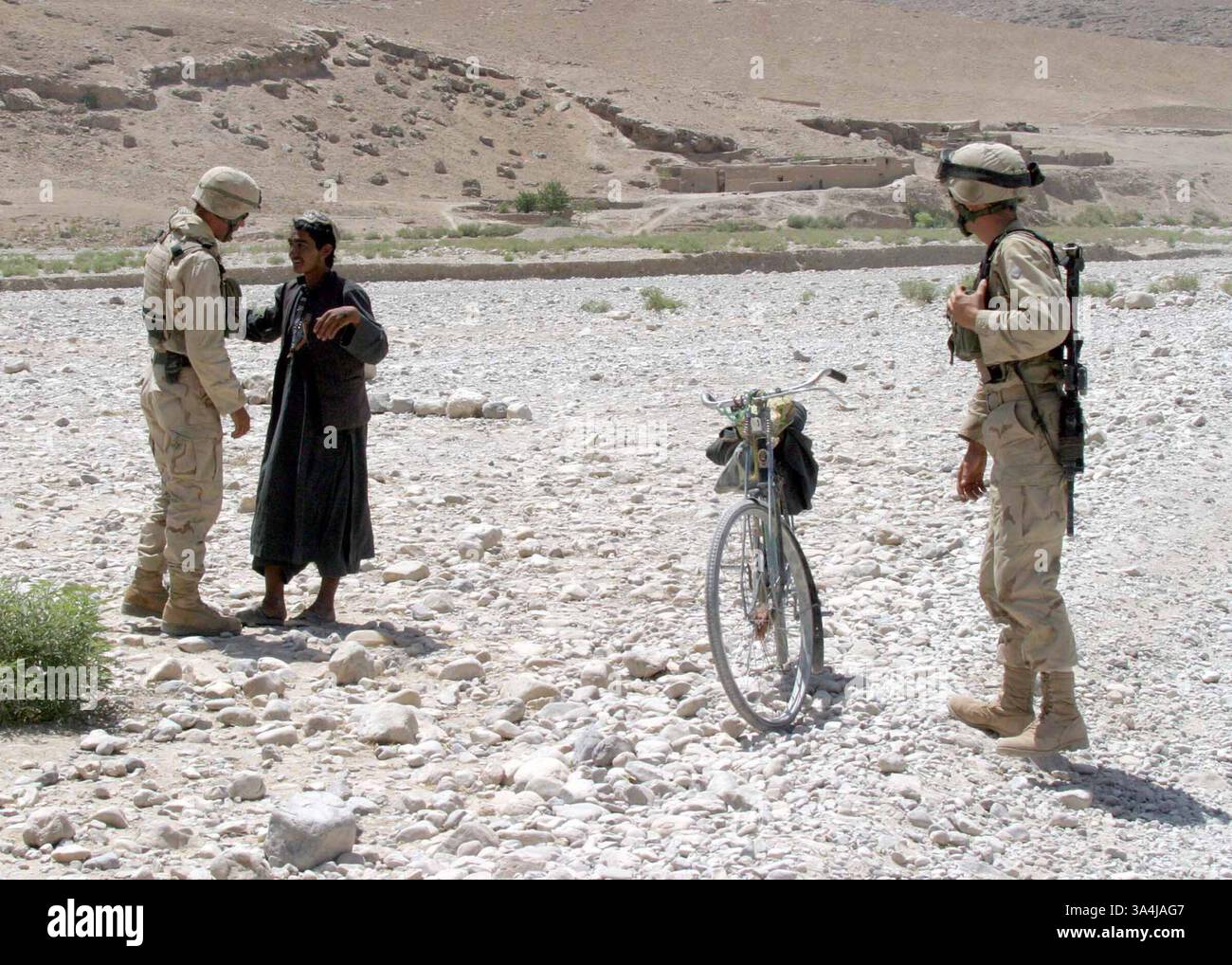 29 giugno 2004; Centro, Afghanistan; Marines del Combined Anti-Armor Team (CAAT) del Battalion Landing Team 1st Bn., 6th Marines interrogano un uomo afghano a un checkpoint di veicolo (VCP) nell'Afghanistan centrale. Il BLT 1/6 è l'elemento da combattimento terrestre della 22nd Marine Expeditionary Unit (Special Operations Capable). Foto Stock