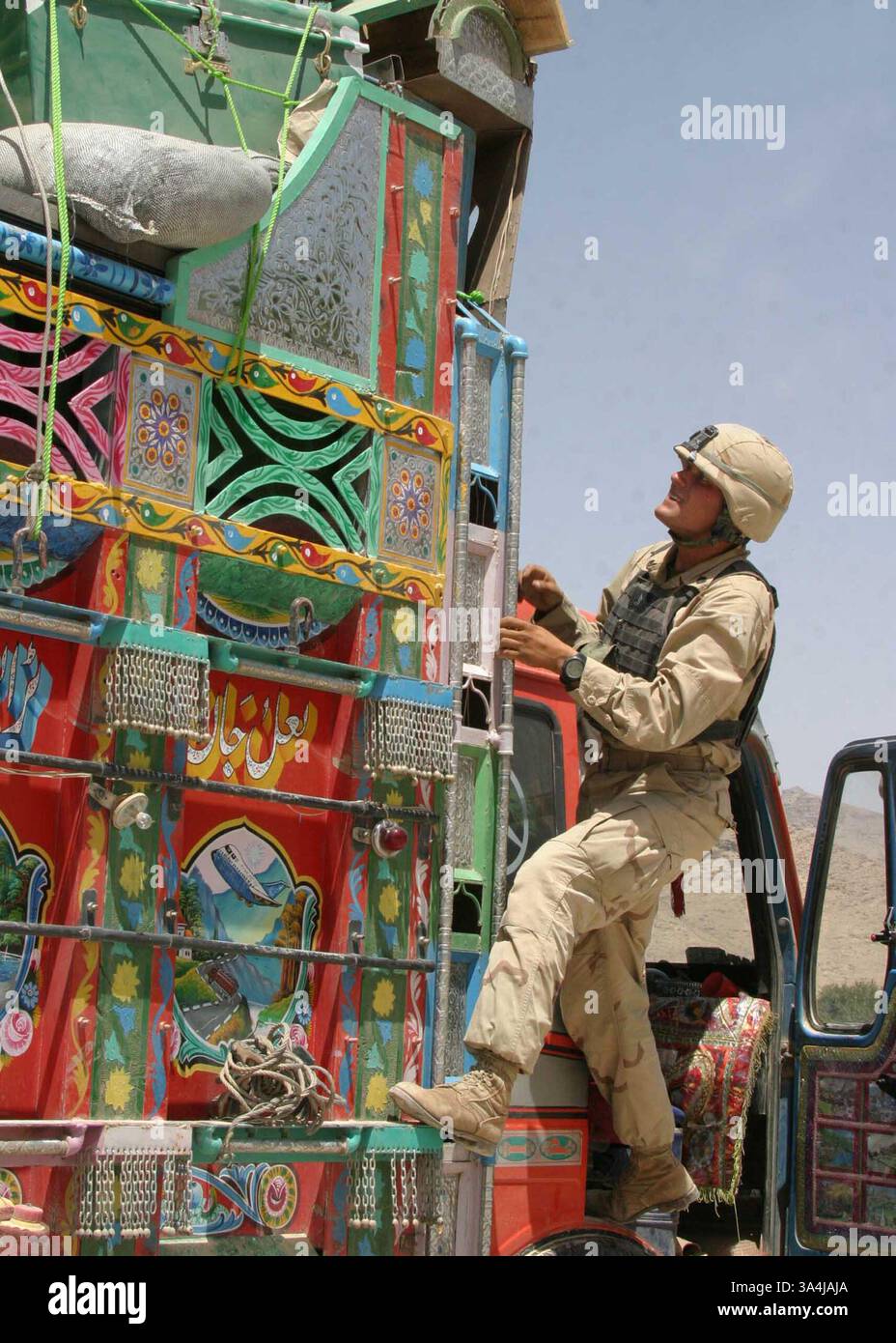 29 giugno 2004; centro, Afghanistan; staff Sgt. JEREMY COPPLPA del Combined Anti-Armor Team (CAAT) del Battalion Landing Team 1st Bn., 6th Marines sale su un camion jingle in un checkpoint per veicoli (VCP) nell'Afghanistan centrale. Il BLT 1/6 è l'elemento da combattimento terrestre della 22nd Marine Expeditionary Unit (Special Operations Capable). Foto Stock