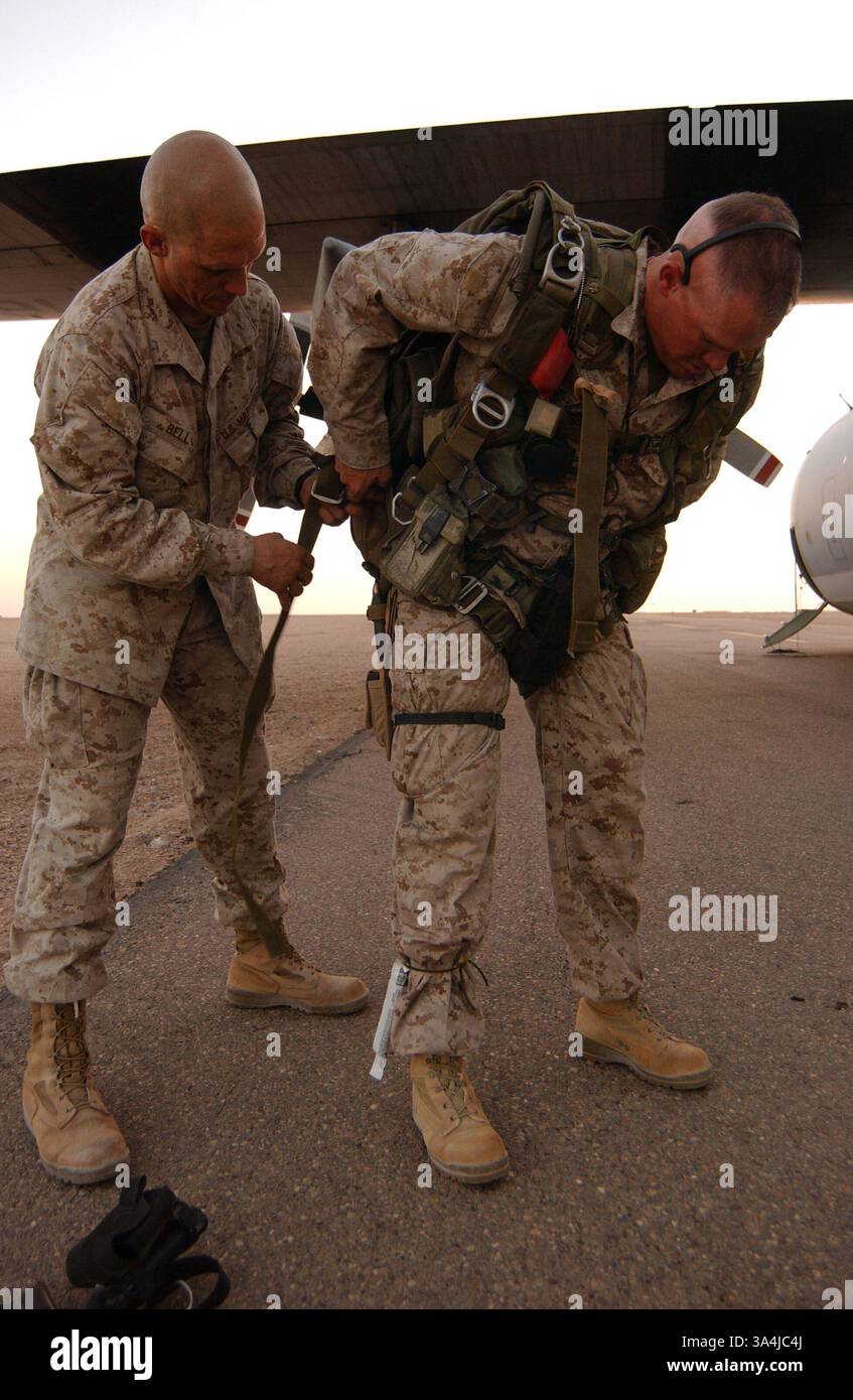 23 luglio 2004; al Taqaddum, Iraq; 1st Sgt. JOHN K. BELL, Alpha Company 1st Sgt., 1st Reconnaissance Battalion, i Marine Expeditionary Force, regola un paracadute per Gunnery Sgt. BRANDON L. DESILET, assistente operatore radio, 1st Recon Batt. Al Taqaddum, Iraq, 23 luglio. I due Recon Marines hanno agito come pathfinder saltando ad alta quota in una zona di caduta e segnando un altro DZ per un gruppo separato di Recon Marines che sono stati sganciati da due elicotteri CH-46E Sea Knight. L'intera evoluzione è stata un lavoro di squadra da parte dei Recon Marines e delle risorse dell'aviazione del Marine Aircraft Group 16, 3rd Marine Foto Stock