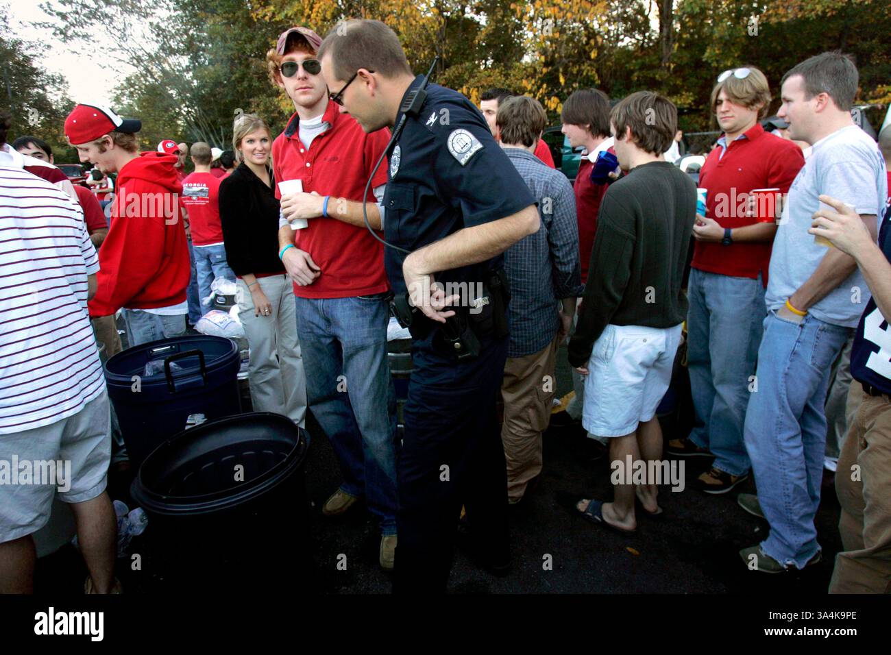 12 novembre 2005; Athens, Georgia, USA; il capo della polizia dell'Università della Georgia Jimmy Williamson controlla una festa in un parcheggio fuori East Campus Road ore prima della partita di football tra l'Università della Georgia e l'Università di Auburn ad Athens, GA, sabato 12 novembre 2005. Andrew Gomez, laureato in UGA, ha detto che ha iniziato una festa regolare in questo posto sei anni fa, quando era una matricola ed è diventata una tradizione in ogni partita casalinga. C'erano 14 fusti di birra alla festa di sabato, ha detto Gomez. Credito obbligatorio: Foto di Allen Sullivan/ZUMA Press. (©) Copyright 2005 di Allen Sullivan Foto Stock
