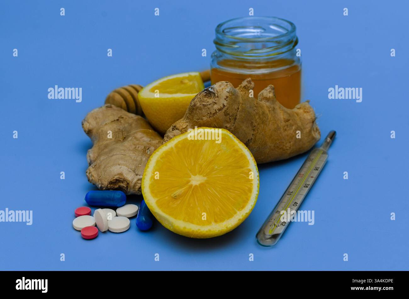 Una composizione di rimedi naturali e farmaci farmaceutici per il trattamento dei sintomi del raffreddore e dell'influenza. L'immagine presenta limone fresco, radice di zenzero, levigare Foto Stock