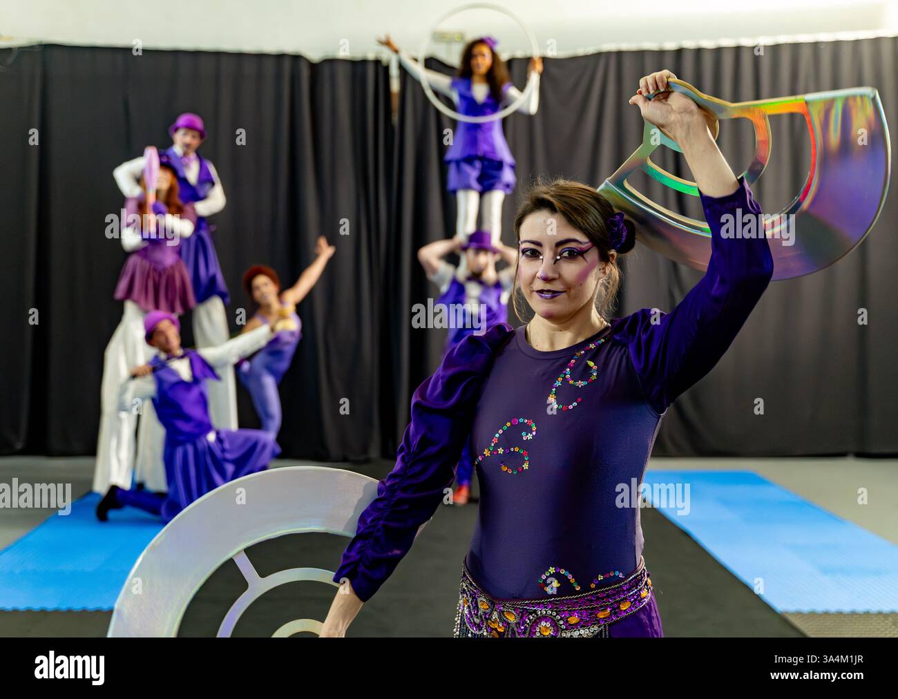 Artisti del circo che tengono vari oggetti di scena durante una prova, mostrando le loro abilità e coordinazione Foto Stock Artisti del circo che tengono vari oggetti di scena durante una prova, mostrando le loro abilità e coordinazione Foto Stock