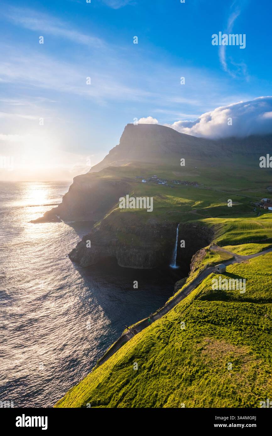 Vista aerea della cascata Mulafossur con il piccolo villaggio di Gasadalur. Isola di Vagar, Isole Faroe, Danimarca, Europa. Foto Stock