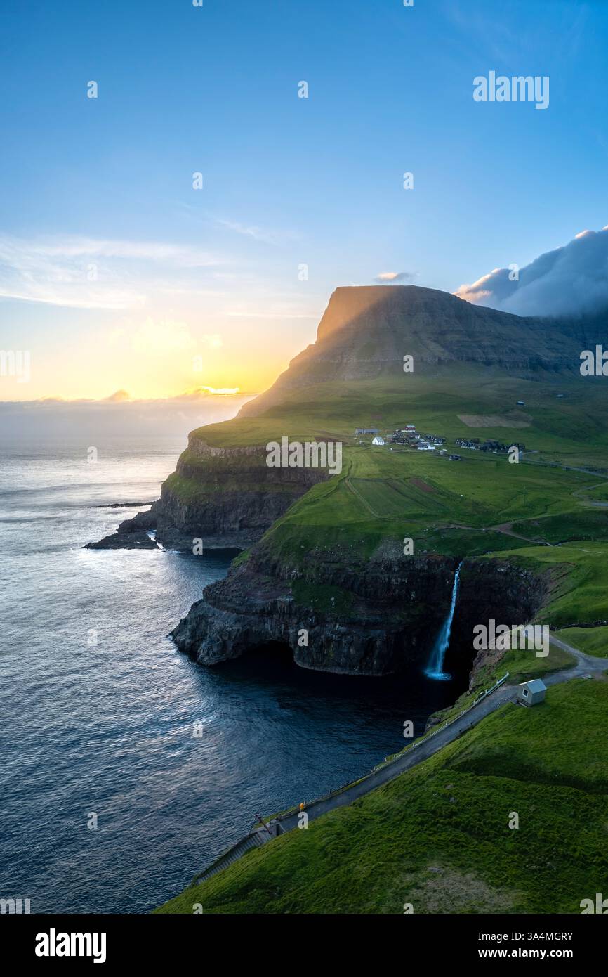 Vista aerea della cascata Mulafossur con il piccolo villaggio di Gasadalur. Isola di Vagar, Isole Faroe, Danimarca, Europa. Foto Stock