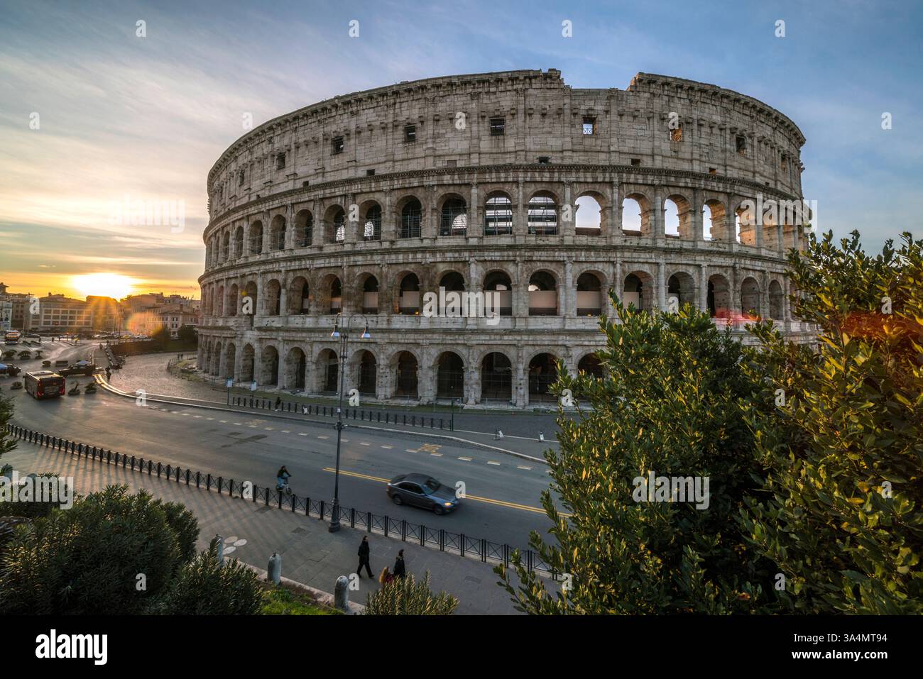 I raggi di luce del mattino illuminano un nuovo giorno sull'antico Colosseo di Roma. Foto Stock