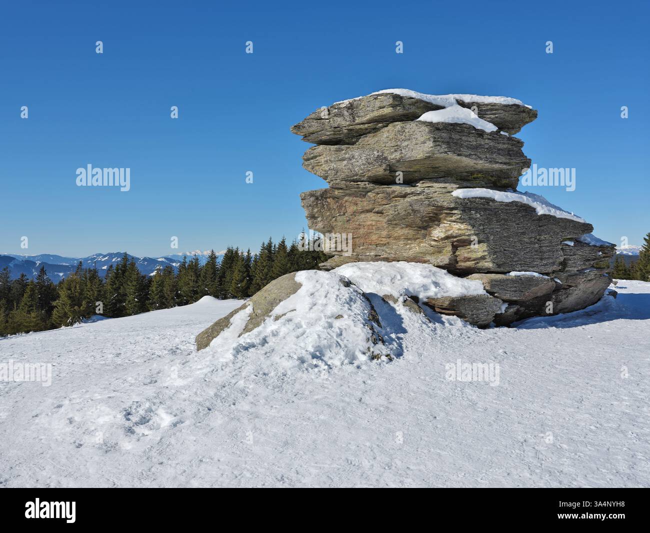 Soleggiato paesaggio invernale con possenti blocchi di pietra sotto il vivace cielo blu. Teufelstein, Stiria, Austria. Foto Stock