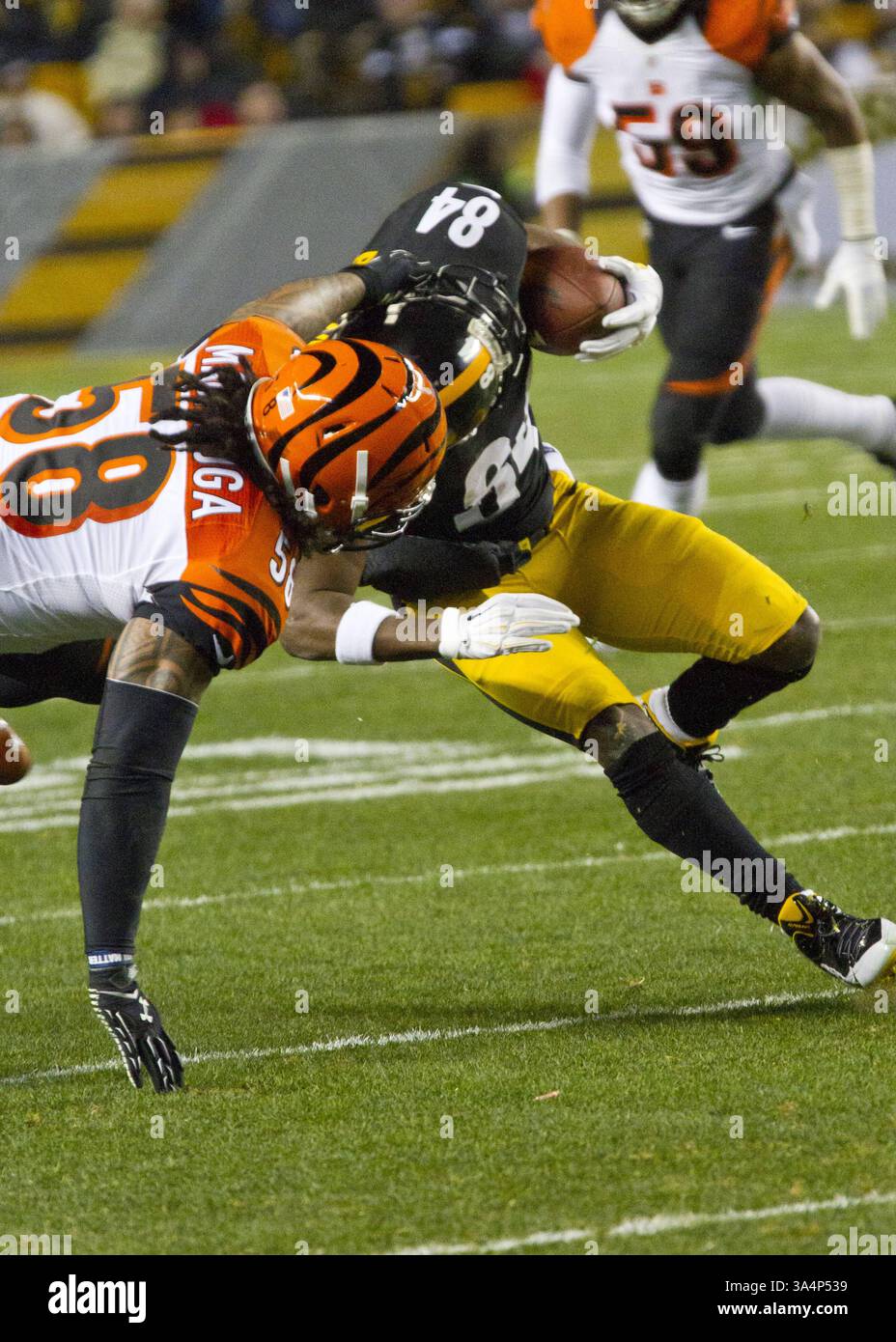 28 dicembre 2014 - Pittsburgh, Pennsylvania, U. S - il middle linebacker dei Cincinnati Bengals Rey Maualuga (58) tira il wide receiver dei Pittsburgh Steelers Antonio Brown (84) giù per la maschera. I Pittsburgh Steelers sconfissero i Cincinnati Bengals 27-17 domenica sera all'Heinz Field per vincere il titolo di Division della AFC North. (Immagine di credito: © Brian Kunst/ZUMA Wire) Foto Stock