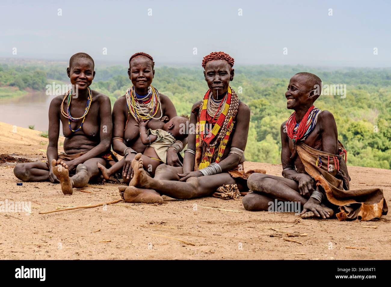 Etiopia, donne della tribù Karo nella valle dell'Omo sedute per una chiacchierata davanti al fiume Omo. 18 febbraio 2024 Foto Stock