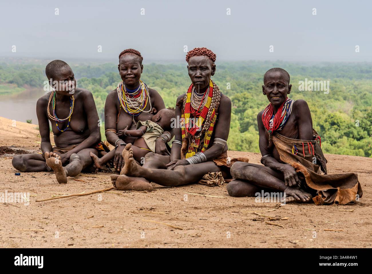 Etiopia, donne della tribù Karo nella valle dell'Omo sedute per una chiacchierata davanti al fiume Omo. 18 febbraio 2024 Foto Stock Etiopia, donne della tribù Karo nella valle dell'Omo sedute per una chiacchierata davanti al fiume Omo. 18 febbraio 2024 Foto Stock