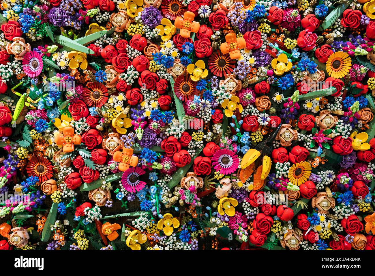 Mattoncini in plastica Lego colorati disposti in un motivo floreale, creando uno sfondo vivace e giocoso Foto Stock