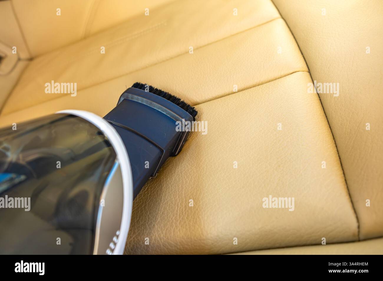 Piccolo aspirapolvere portatile alimentato a batteria, per pulire i rifiuti negli interni dell'auto, rinnovare la tappezzeria beige del seggiolino Foto Stock