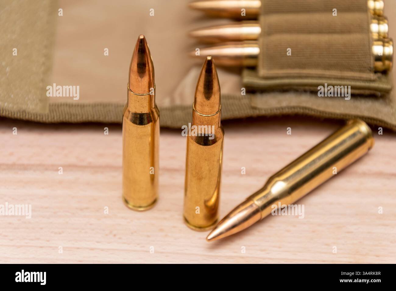 Cartucce per pistola e custodia tattica su sfondo di legno. Foto Stock