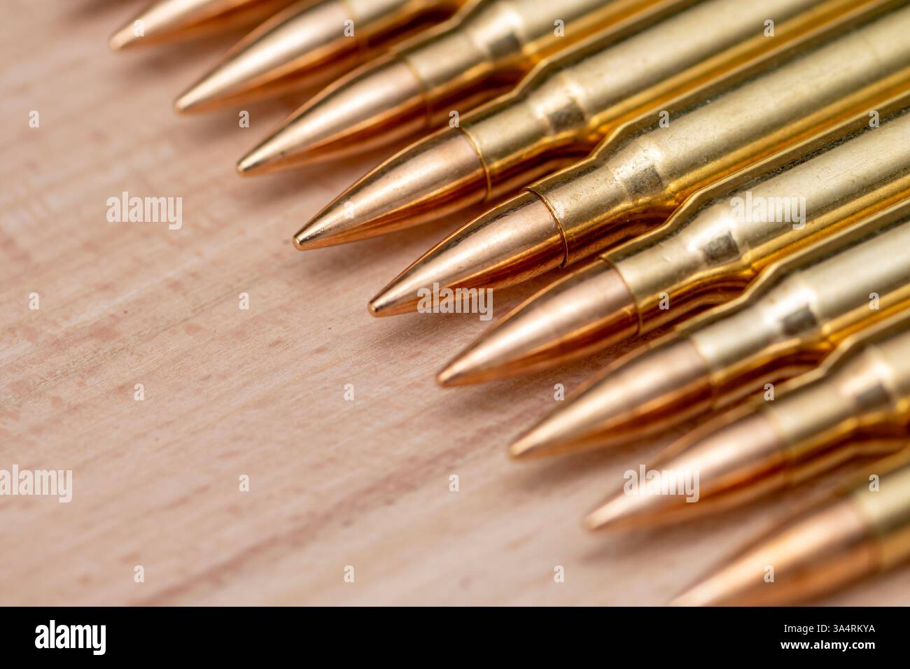 cartucce di fucile, allineate su uno sfondo di legno Foto Stock