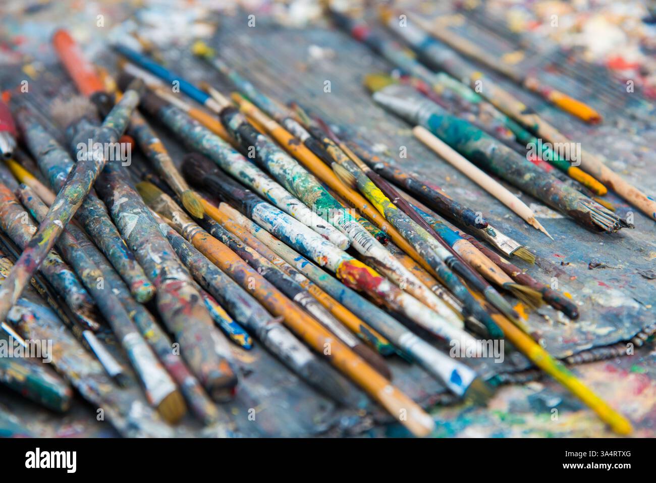 Sfondi. Primo piano di pennelli artistici su un vassoio all'aperto. Gruppo di oggetti disordinato Foto Stock