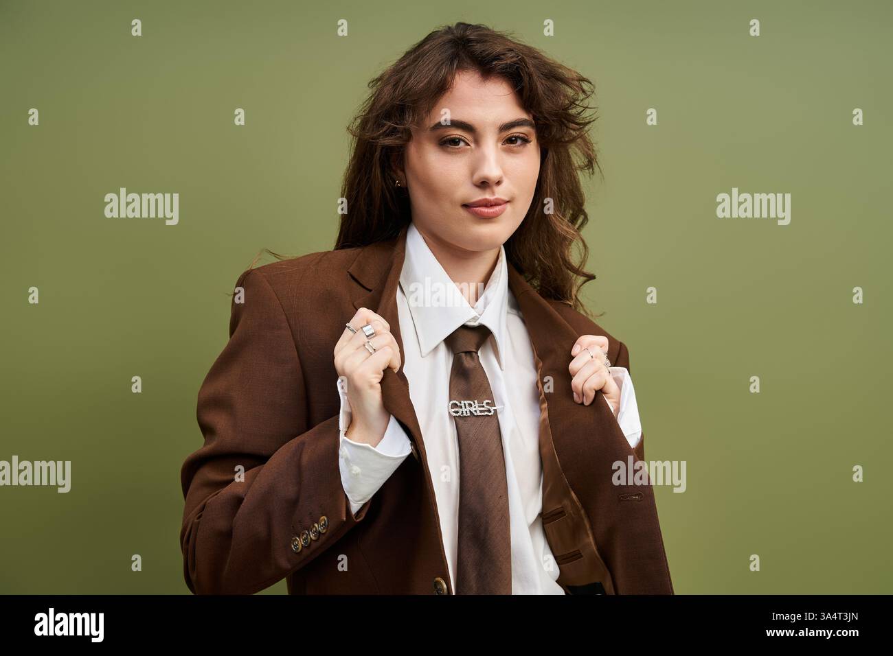 Una giovane e graziosa donna modella il suo outfit chic, mettendo in risalto i dettagli alla moda e lo stile sicuro di sé. Foto Stock