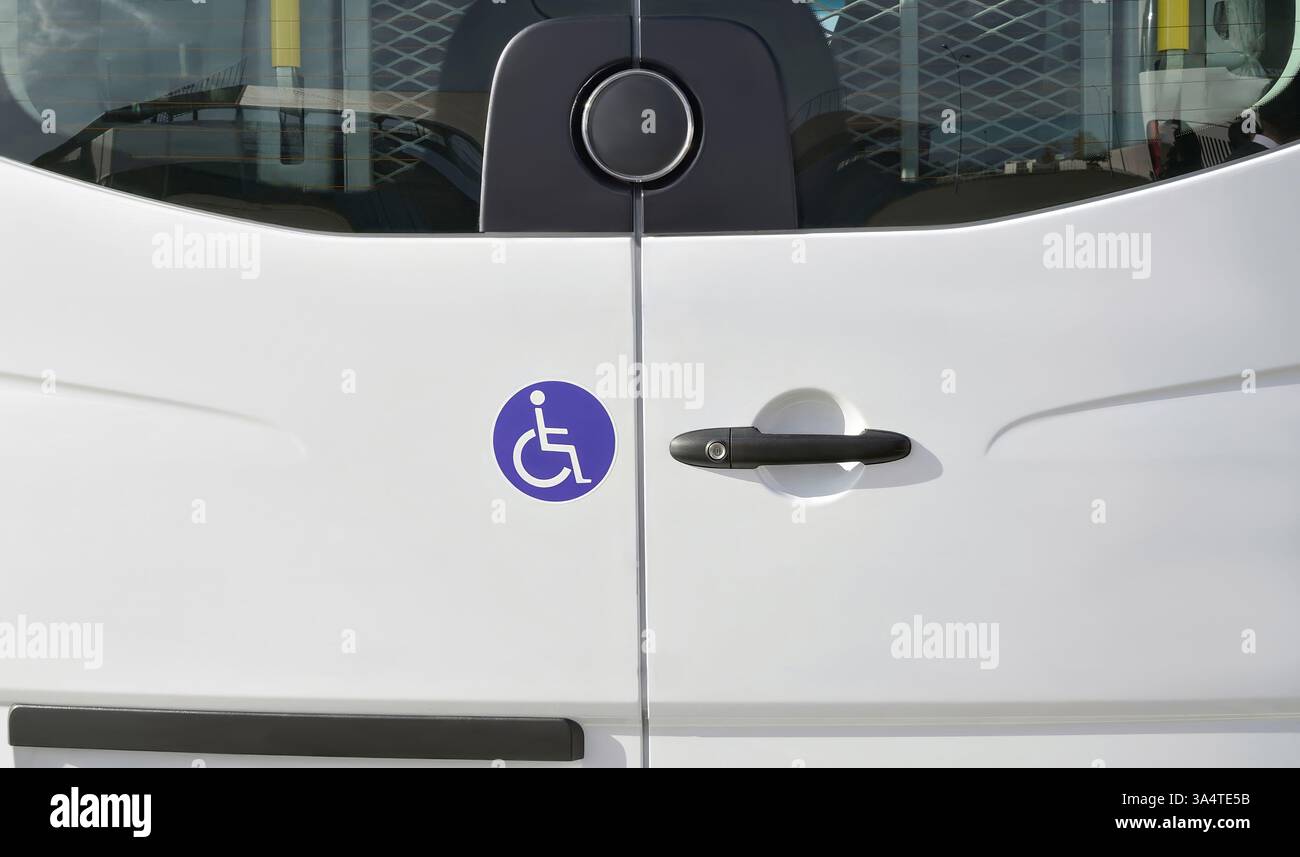 Porte posteriori di un veicolo bianco per il trasporto di persone a mobilità ridotta con il simbolo di una persona su una sedia a rotelle. Foto Stock
